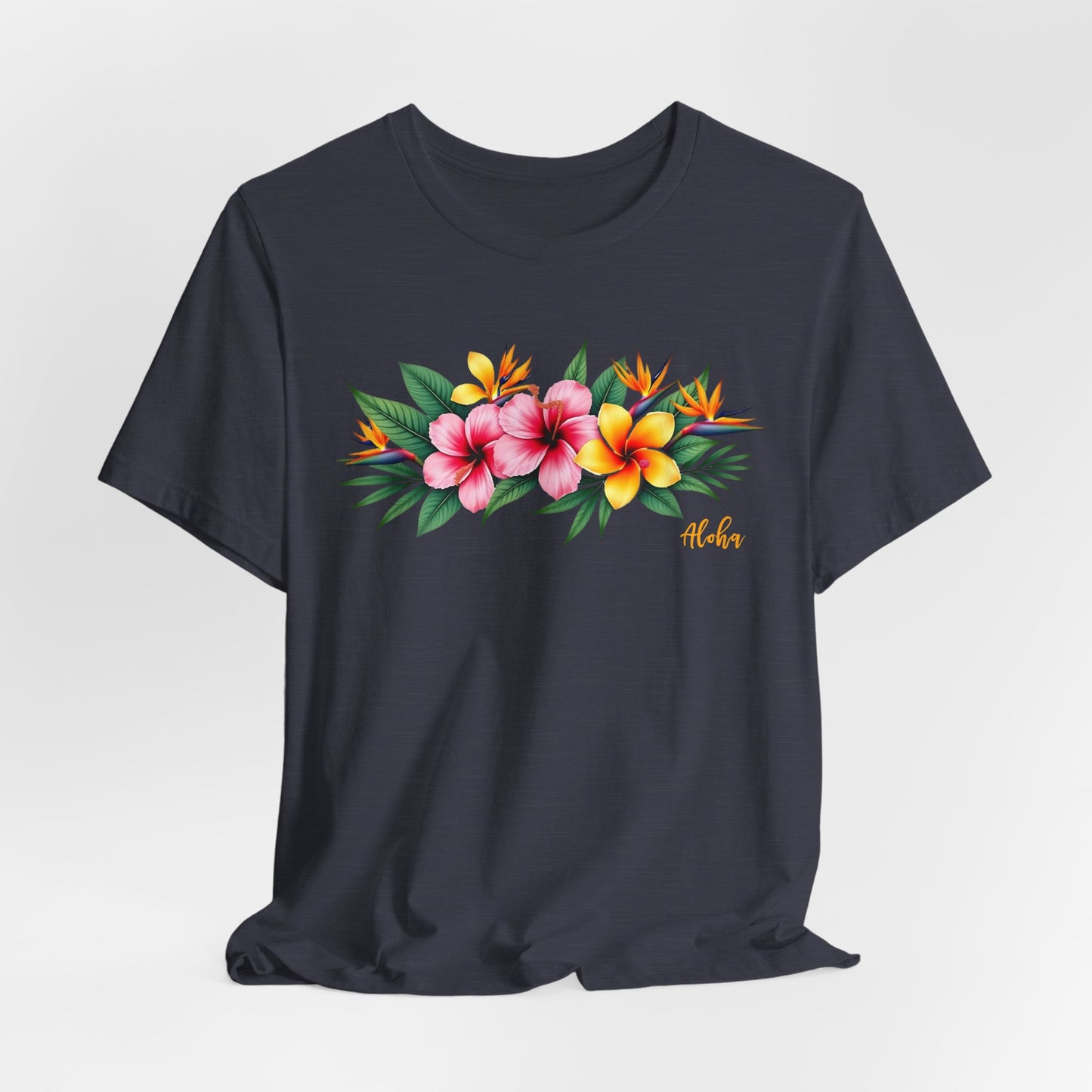 The Tropical Floral Unisex Jersey T-Shirt – Perfect for Summer Vibes features a vibrant floral print with pink, yellow, and orange tropical flowers, green leaves, and “Aloha” in yellow script. Made from soft Airlume combed cotton.