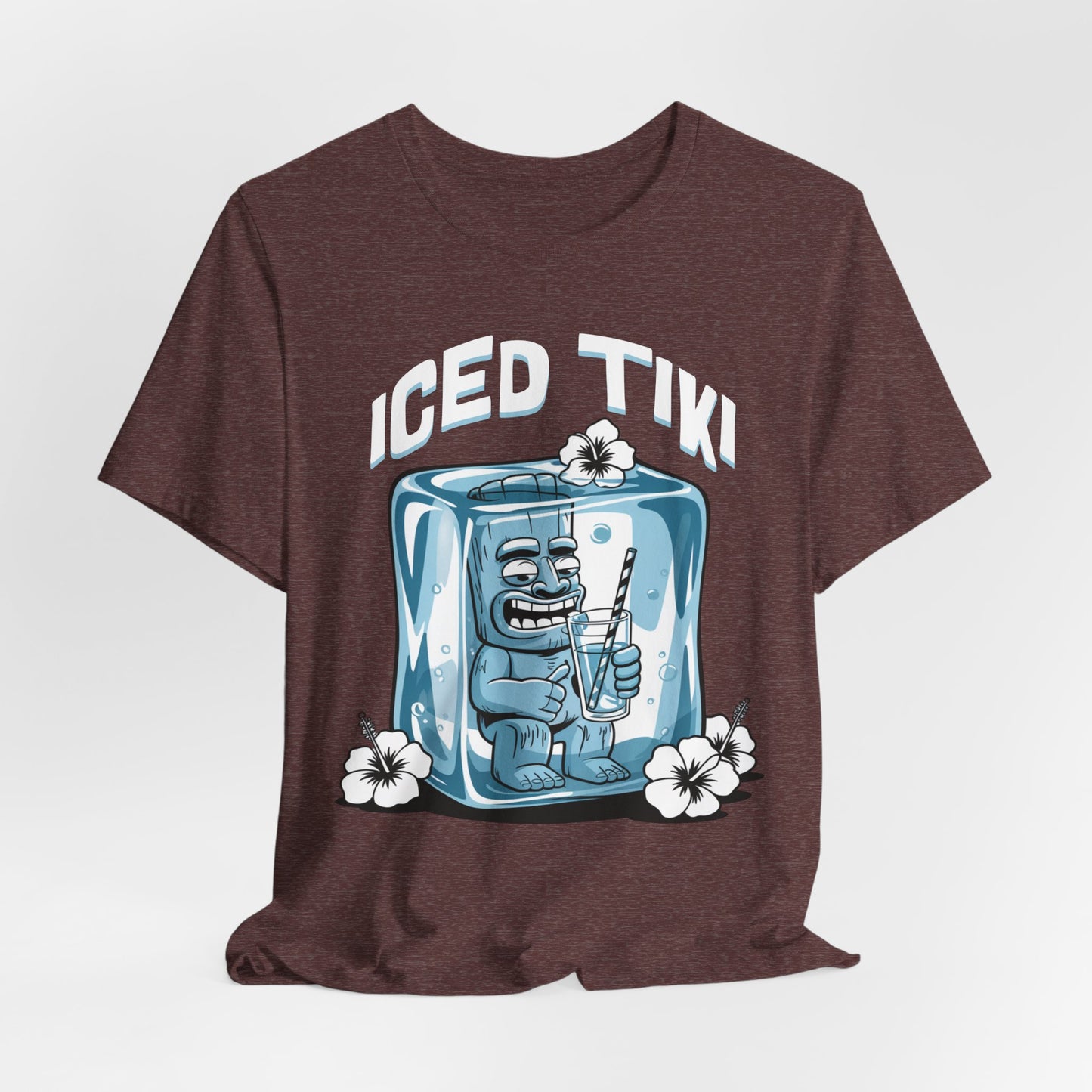 The Iced Tiki Unisex Jersey Tiki T-Shirt - Summer Vibes T-Shirt features a smiling blue tiki statue in an ice cube sipping from a straw, white tropical flowers, and ICED TIKI text. Made from breathable lightweight fabric.