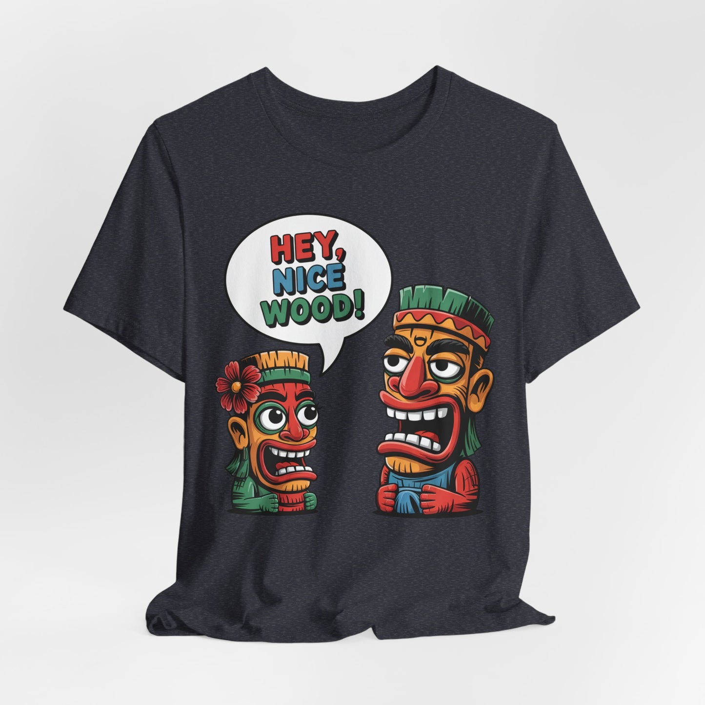 The Tropical Humor Short Sleeve Tiki T-Shirt - Hey, Nice Wood! Graphic features two vibrant cartoon tiki characters with exaggerated faces and tribal patterns; one says “HEY, NICE WOOD!” in a speech bubble.
