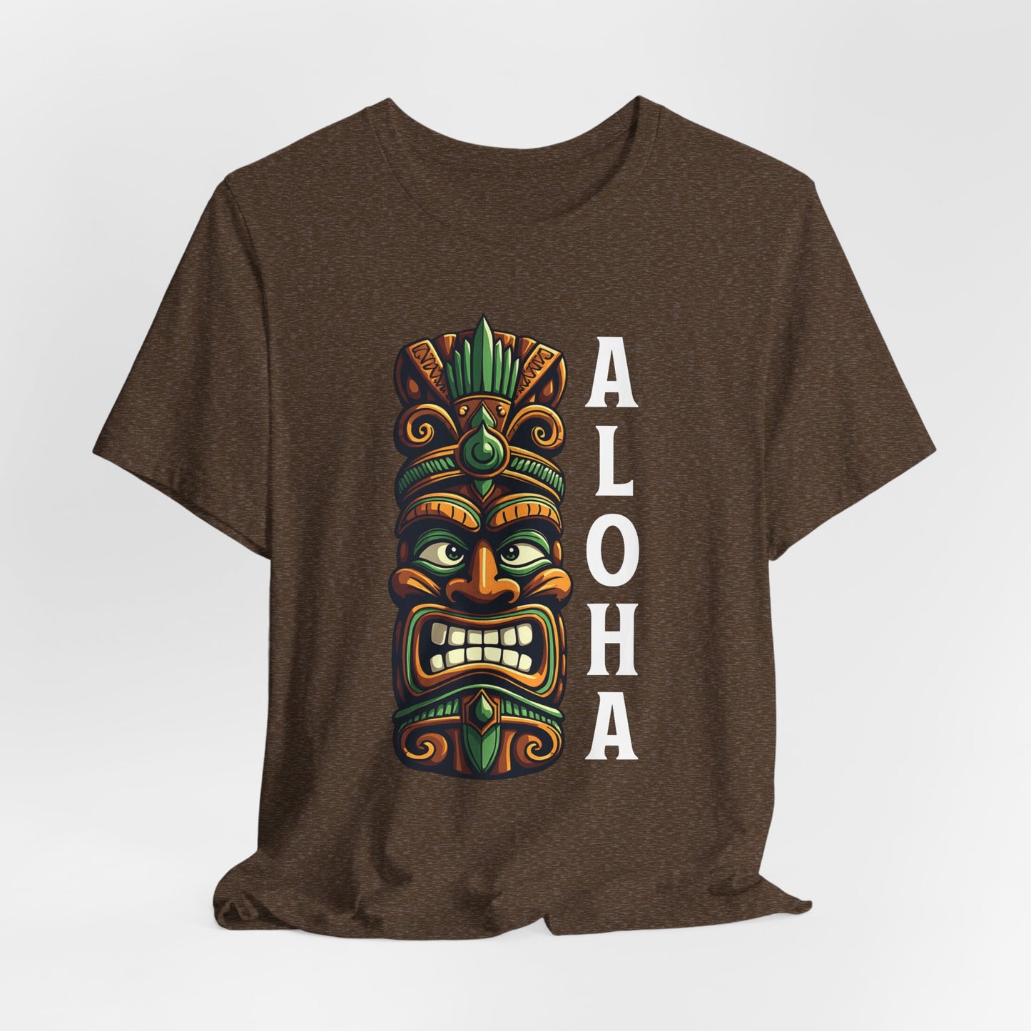 The Aloha Tiki- Graphic Tiki T-Shirt for Beach Lovers is a brown unisex jersey tee with a vibrant tiki mask and bold white “ALOHA”—ideal for anyone who loves the beach and dreams of a tropical escape.