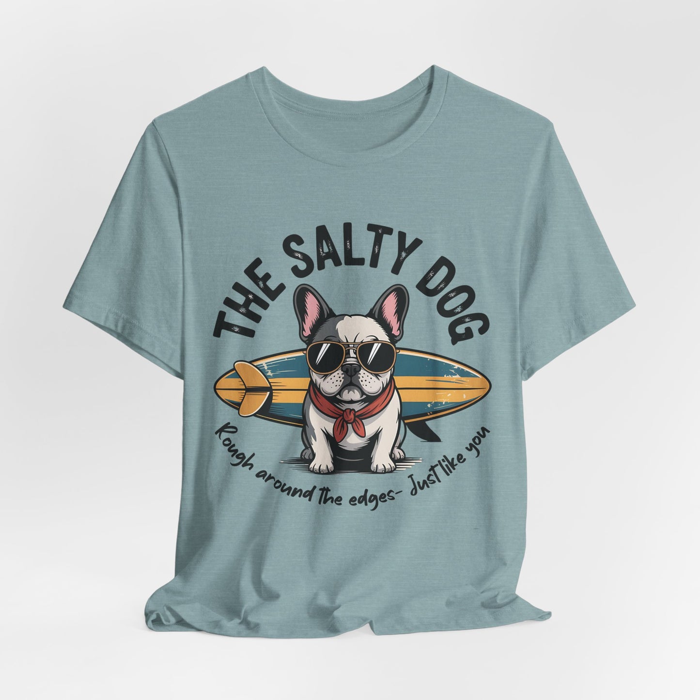 The Salty Dog Unisex Surf T-Shirt in blue features a playful dog in sunglasses and red bandana with a surfboard. Perfect for beach outings! Text: The Salty Dog and Rough around the edges—Just like you.