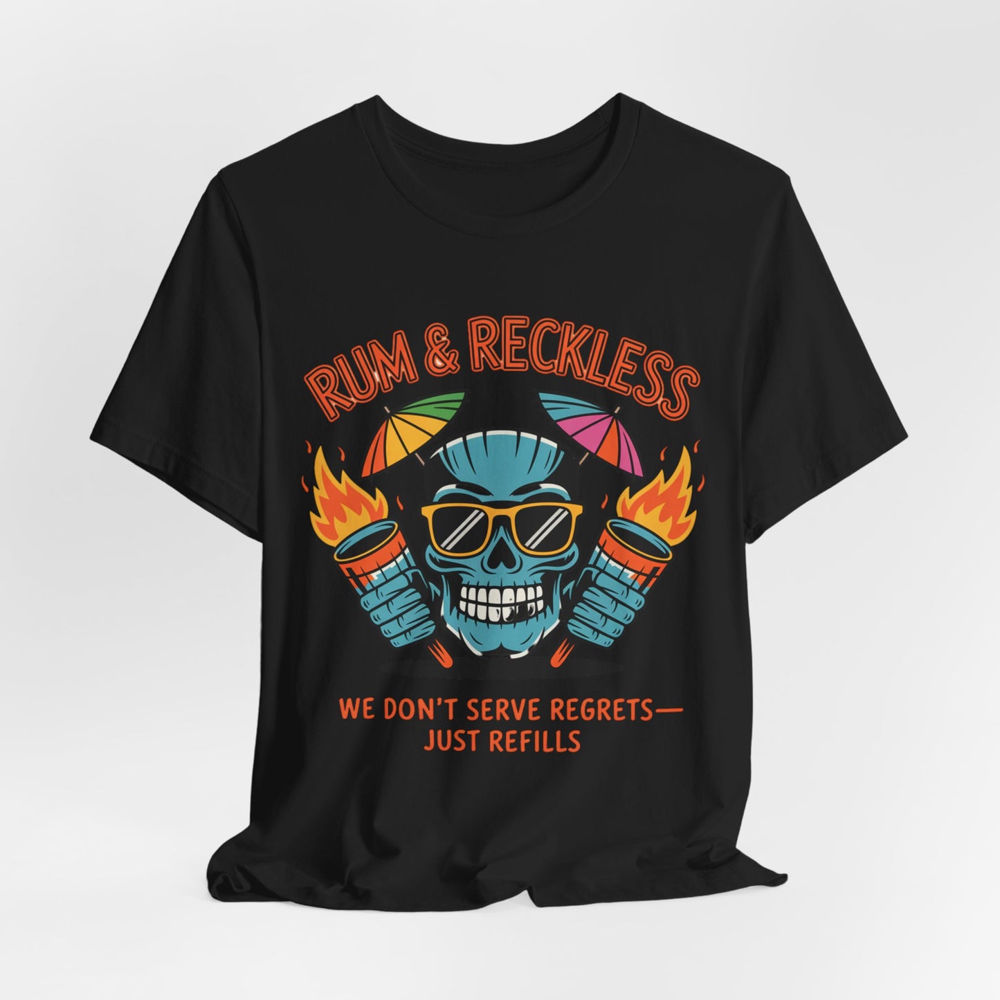 The Rum & Reckless Skull Tiki T-Shirt features a colorful skull with sunglasses, a hat, and flaming cocktails. Perfect for summer parties or beach days. Text: RUM & RECKLESS above, WE DONT SERVE REGRETS—JUST REFILLS below.
