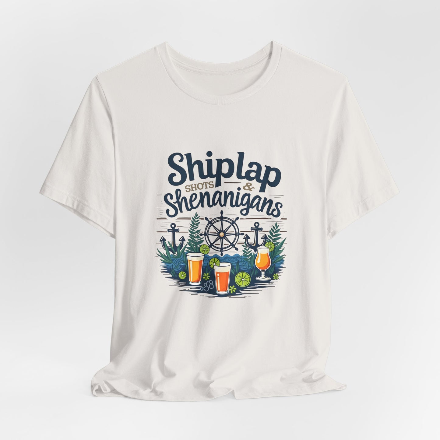 The Shiplap Shenanigans Unisex Short Sleeve Tee is crafted from soft Airlume cotton and features a nautical Shiplap Shots & Shenanigans design with anchors, ship wheel, pine branches, lime wedges, and three beer glasses—ideal for brewery lovers.