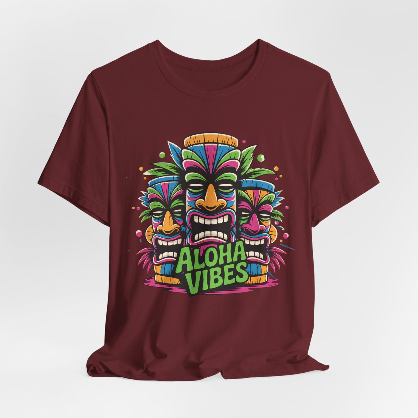 The Aloha Vibes Unisex Short Sleeve Tiki T-Shirt features three vibrant tiki masks and bright green Aloha Vibes text—a tropical graphic tee perfect for beach lovers and summer festivals.