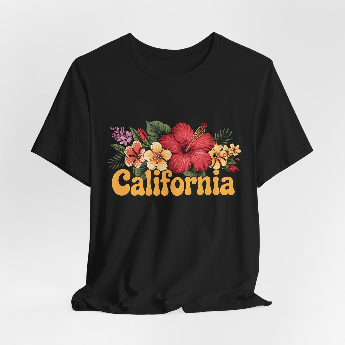 The California Floral Graphic T-Shirt Summer Vibes Unisex T-Shirt features a vibrant design of tropical flowers and green leaves above bold, retro yellow-orange “California” lettering.