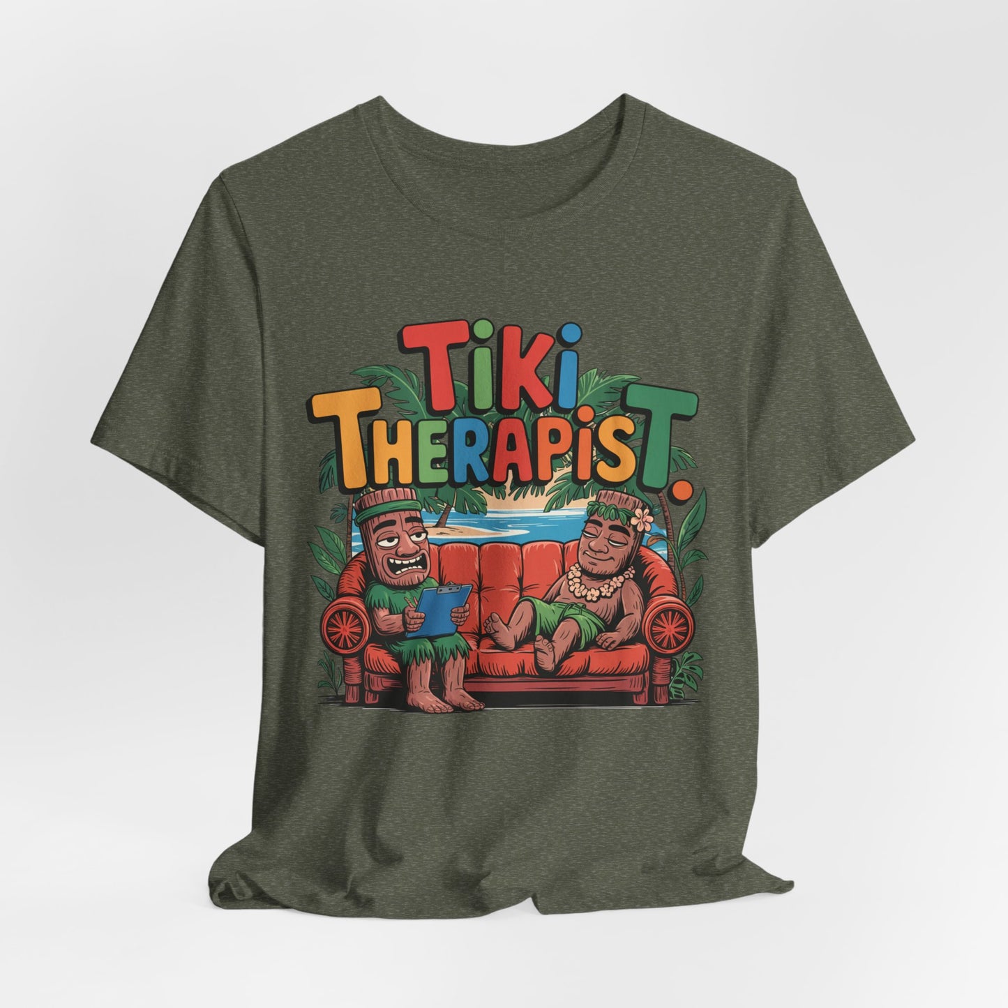 The Tiki Therapist Unisex Tiki T-Shirt is a breathable cotton tee featuring cartoon Tikis on a red couch with Tiki Therapist text and vibrant leaves, perfect for beach lovers seeking fun Hawaiian flair.