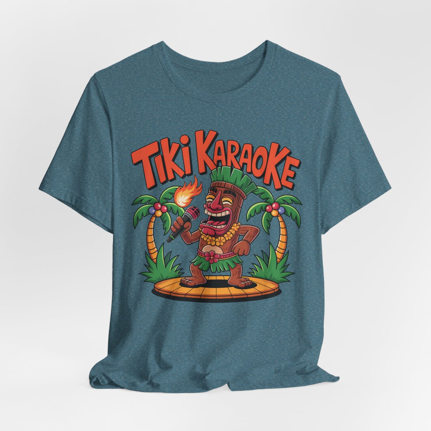 The Tiki Karaoke Unisex Short Sleeve Tiki T-Shirt features a colorful cartoon tiki with a flaming torch on stage between palm trees and bold red Tiki Karaoke text above, creating a fun summer vibe.