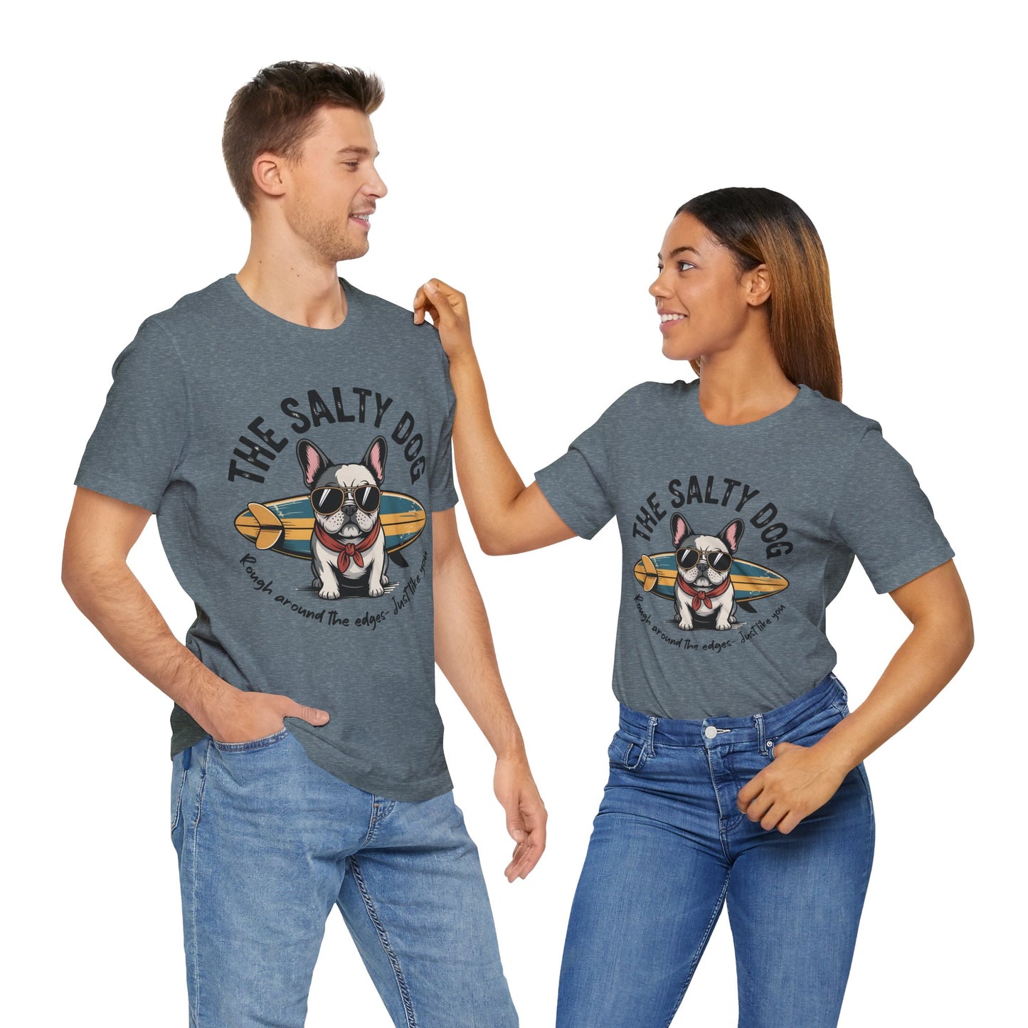 A man and a woman smile at each other in matching gray The Salty Dog Unisex Surf T-Shirts featuring a French bulldog with sunglasses and a scarf on a surfboard—perfect for fun beach outings.