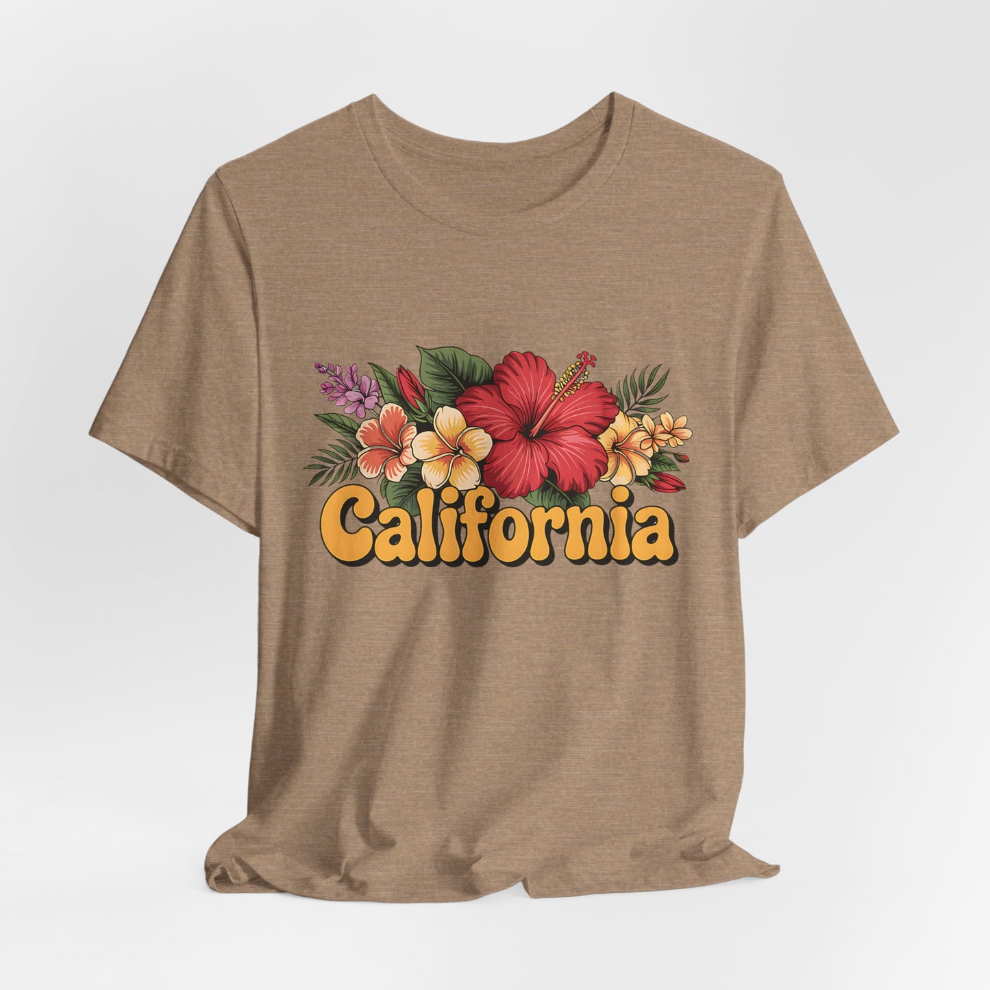The California Floral Graphic T-Shirt features a tan base with hibiscus and plumeria blooms, green leaves, purple accents, and bold retro yellow California lettering. This Summer Vibes Unisex Jersey Short Sleeve Tee offers vibrant coastal style.