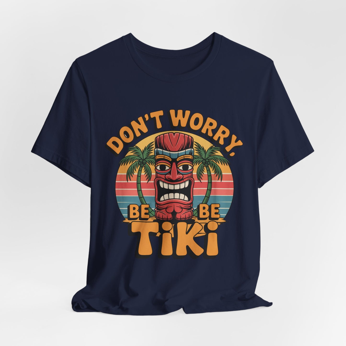 Bring tropical vibes to your look with the Tiki Vibes Unisex Jersey Tiki T-Shirt, featuring a navy base, colorful tiki mask, palm trees, striped sunset, and DONT WORRY, BE TIKI graphic.