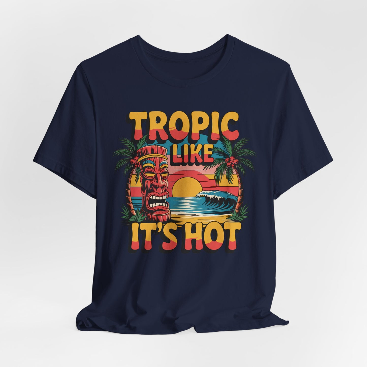 The Tropic Like Its Hot Unisex Tiki T-Shirt features a vibrant tiki mask, palm trees, waves, and sunset—perfect for beach days or summer festivals. Enjoy fun vacation vibes in this bold and colorful tee!.