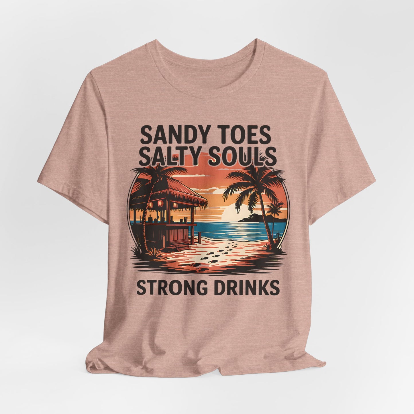 The Sandy Toes Salty Souls Tee – Unisex Jersey Short Sleeve for Beach Lovers features a tropical sunset with tiki hut, palm trees, and waves. Made from soft Airlume combed cotton with bold “Sandy Toes, Salty Souls, Strong Drinks” text.