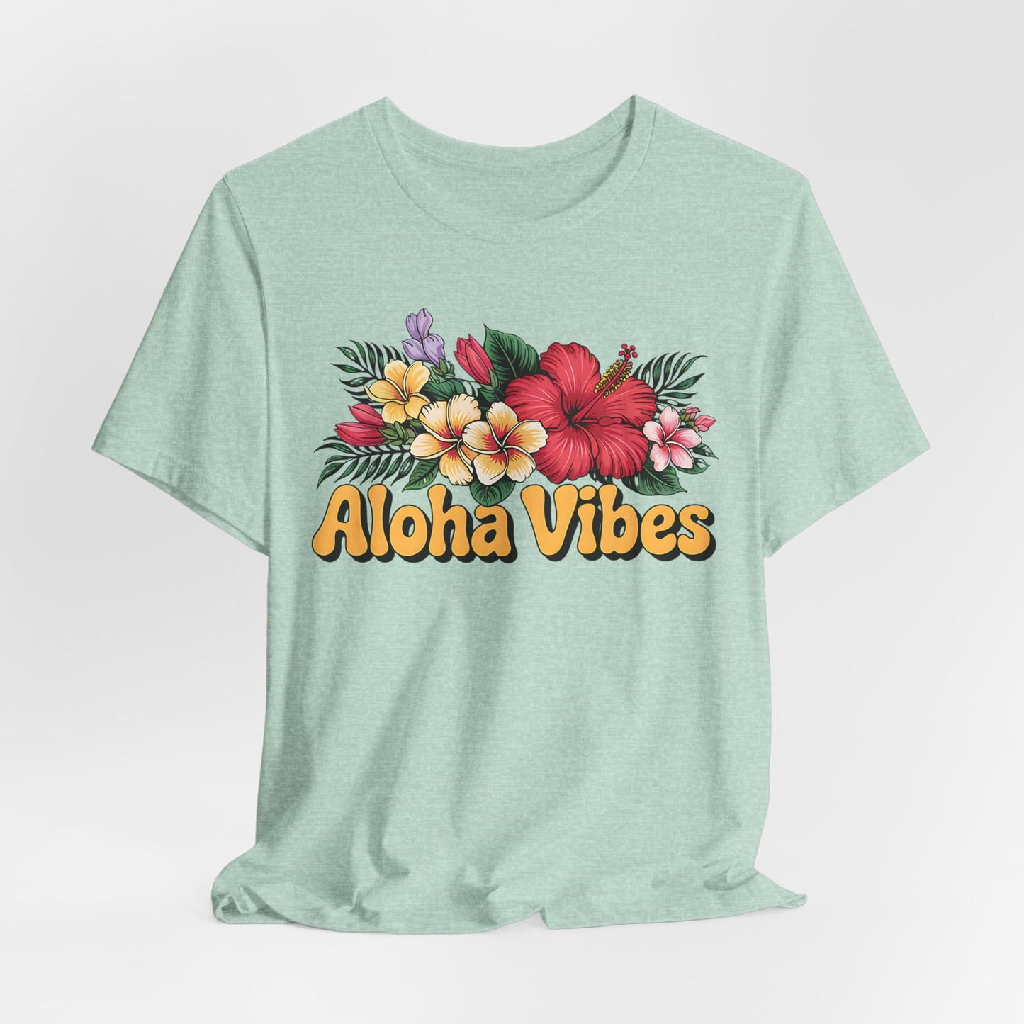 The Aloha Vibes Floral Unisex T-Shirt for Island Vibes features colorful tropical flowers and bold yellow-orange Aloha Vibes text on light green, made from breathable fabric for all-day comfort.