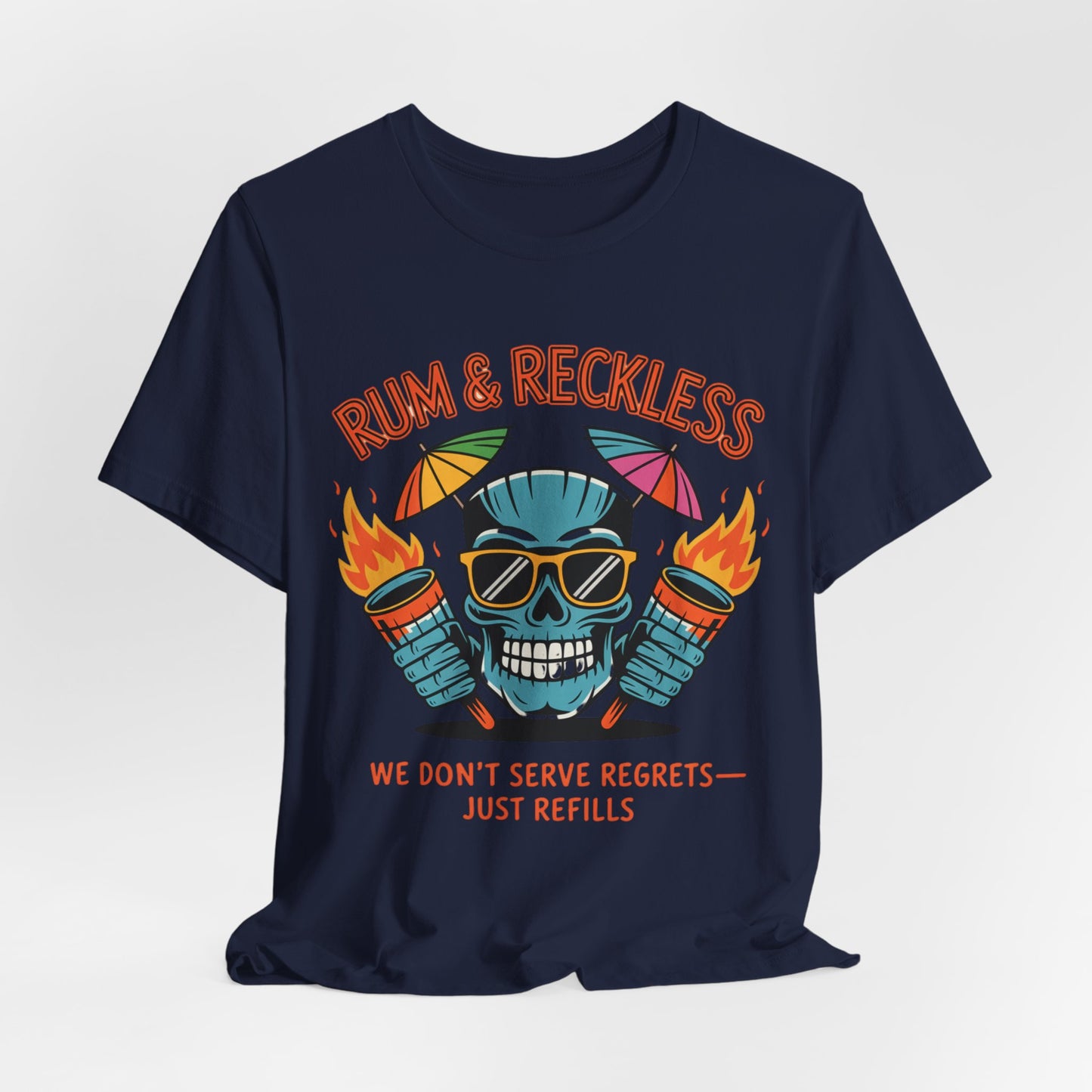 The Rum & Reckless Skull Tiki T-Shirt, perfect for summer parties and beach days, features a colorful skull in sunglasses with flaming rum bottles and bold “RUM & RECKLESS” and “WE DON’T SERVE REGRETS — JUST REFILLS.” text.