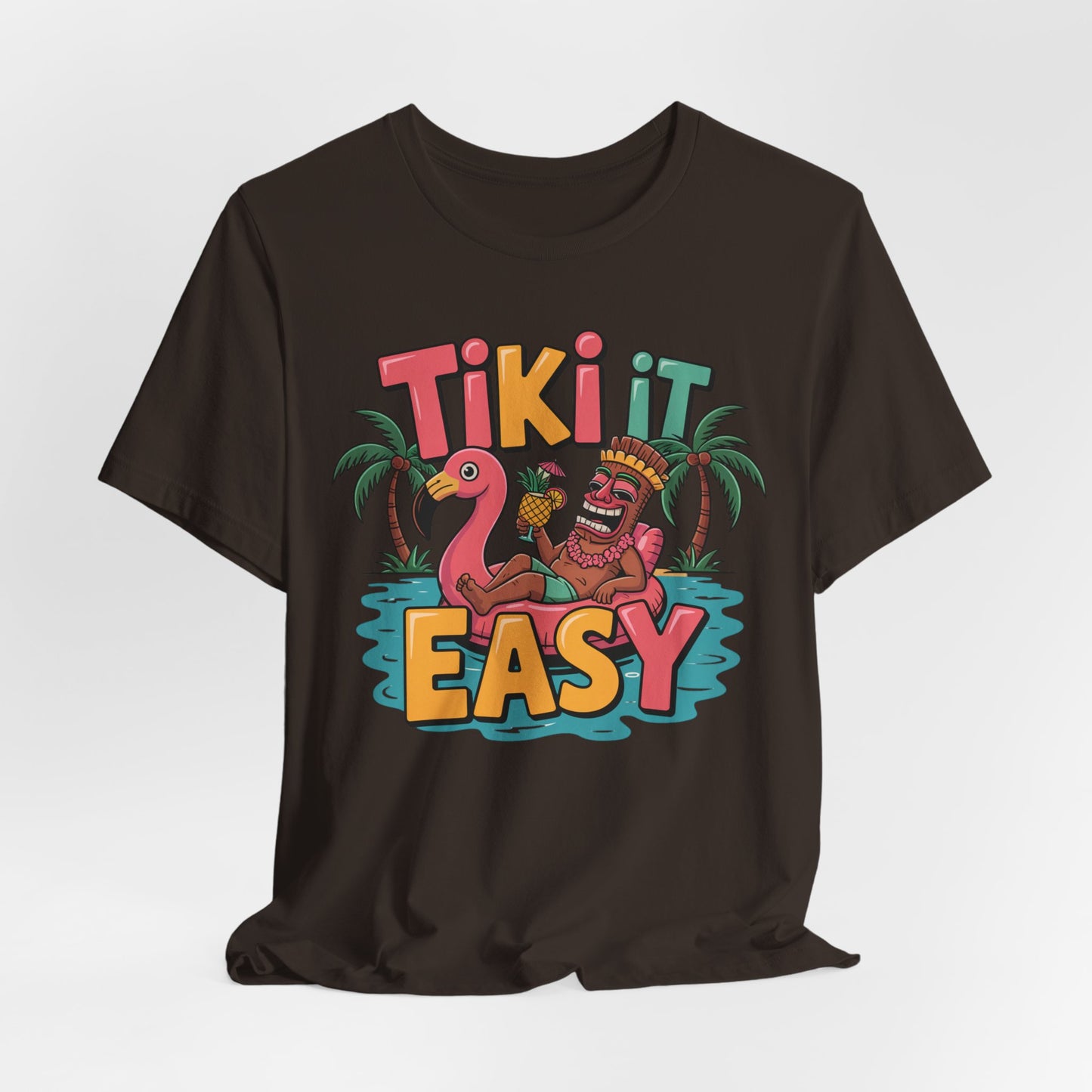 The Tiki It Easy Unisex Short Sleeve Tiki T-Shirt features a vibrant graphic of a tiki statue on a pool float, drink in hand, surrounded by palm trees and tropical beach vibes, with TIKI IT EASY in bold playful lettering.