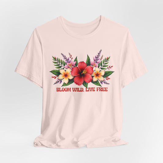 The Bloom Wild, Live Free Floral Tee is a light unisex jersey short sleeve shirt with a vibrant red, yellow, and pink floral design and “BLOOM WILD, LIVE FREE” in red text beneath the flowers on breathable fabric.