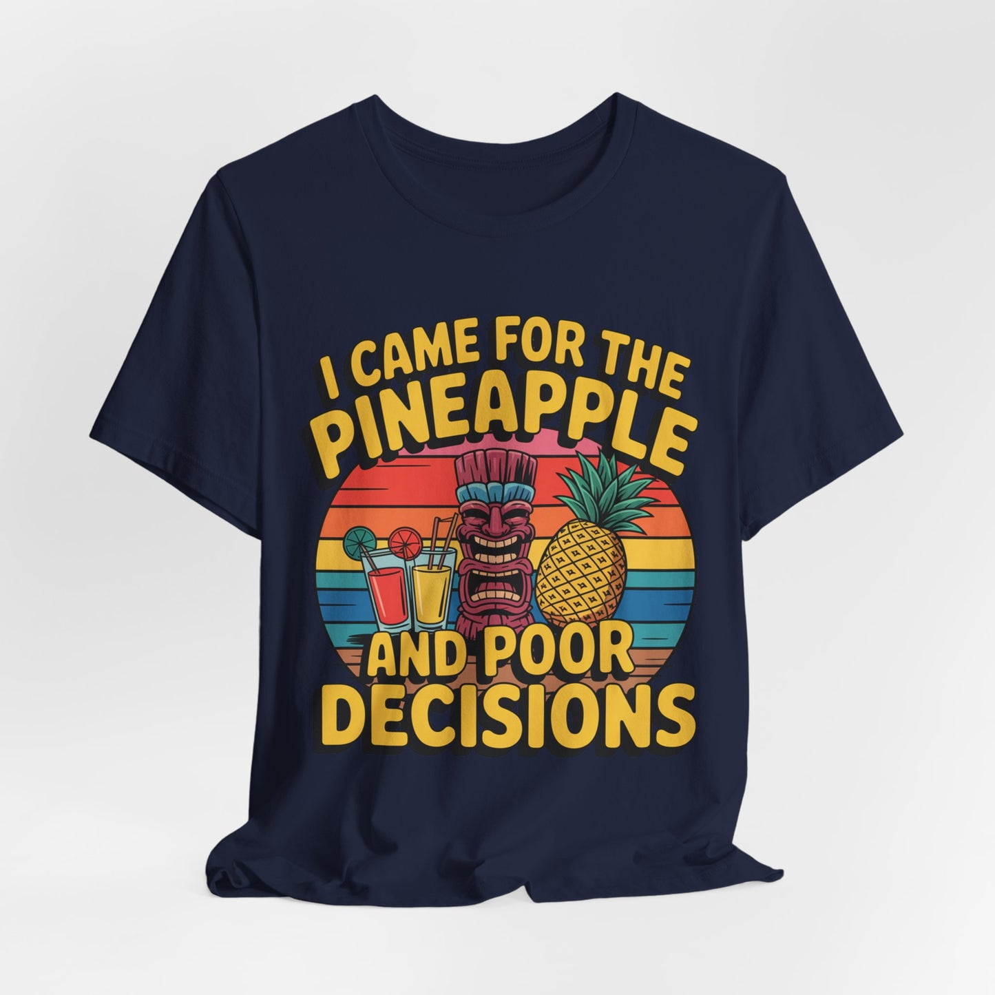 The Tropical Humor Tiki T-Shirt features a navy blue tee with a vibrant tiki head, pineapple, cocktails, and sunset design. Unisex short sleeve. Text: I Came for the Pineapple and Poor Decisions. Perfect for summer fun!.
