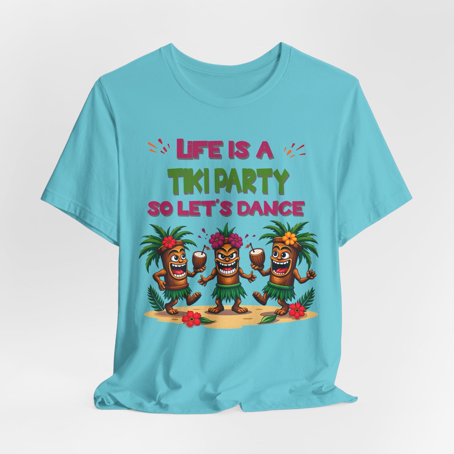 The Tiki Party T-Shirt – Life is a Tiki Party, Lets Dance Shirt for Summer Fun features three playful tiki figures in grass skirts and flower crowns with “Life is a Tiki Party So Let’s Dance” in pink and green, perfect for summer gatherings.