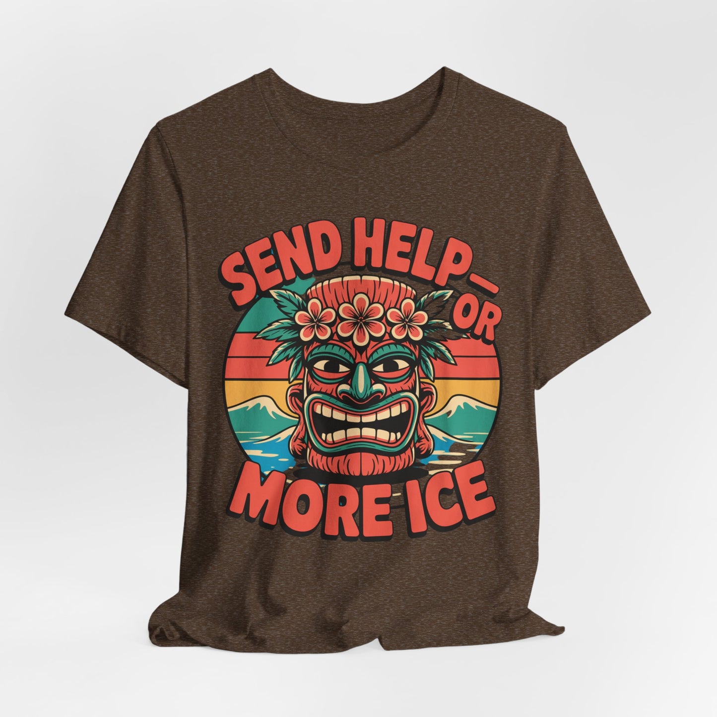The Tropical Vibe Unisex Tiki T-Shirt - Send Help or More Ice in brown features a vibrant tiki mask with flowers, waves, and a sunset. Bold red text around the mask reads SEND HELP OR MORE ICE—ideal for summer festivals and tropical flair.