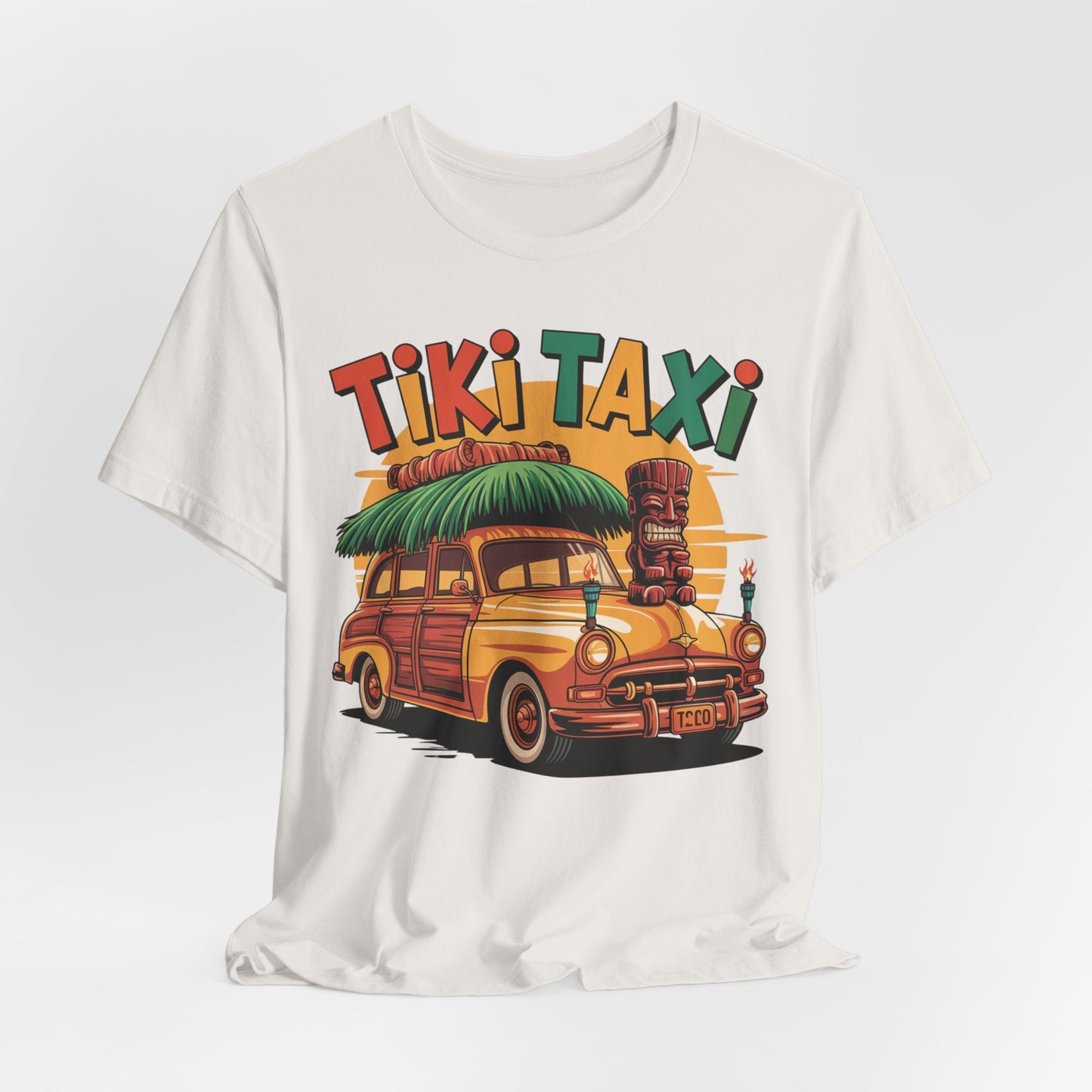 The Tiki Taxi Graphic Tiki T-Shirt for Summer Vibes is a white unisex tee with a retro woodie car, tiki statue, palm leaves, and bold Tiki Taxi print—ideal for beach lovers craving tropical style.