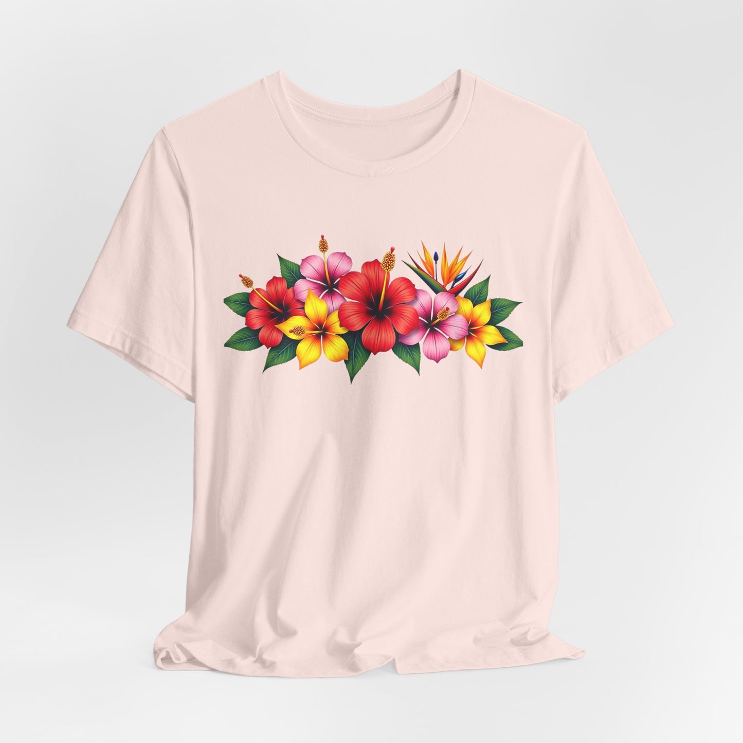 The Tropical Floral Unisex T-Shirt is a light beige summer shirt with a vibrant floral chest print, featuring red, pink, and yellow hibiscus flowers, a bird of paradise, and lush green leaves.