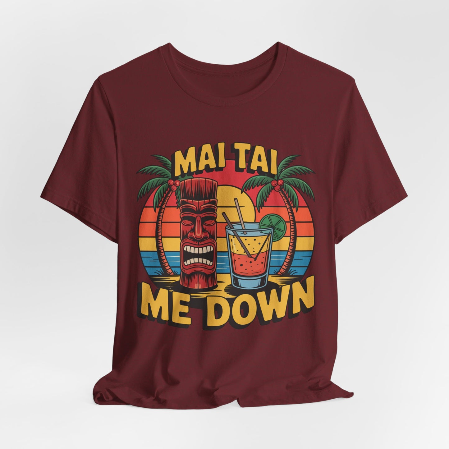 The Mai Tai Me Down Unisex Tiki T-Shirt - Tropical Vibes Summer Shirt features a vibrant tropical drinks print with tiki mask, palm trees, “MAI TAI ME DOWN” text, and sunset stripes on soft Airlume combed cotton.