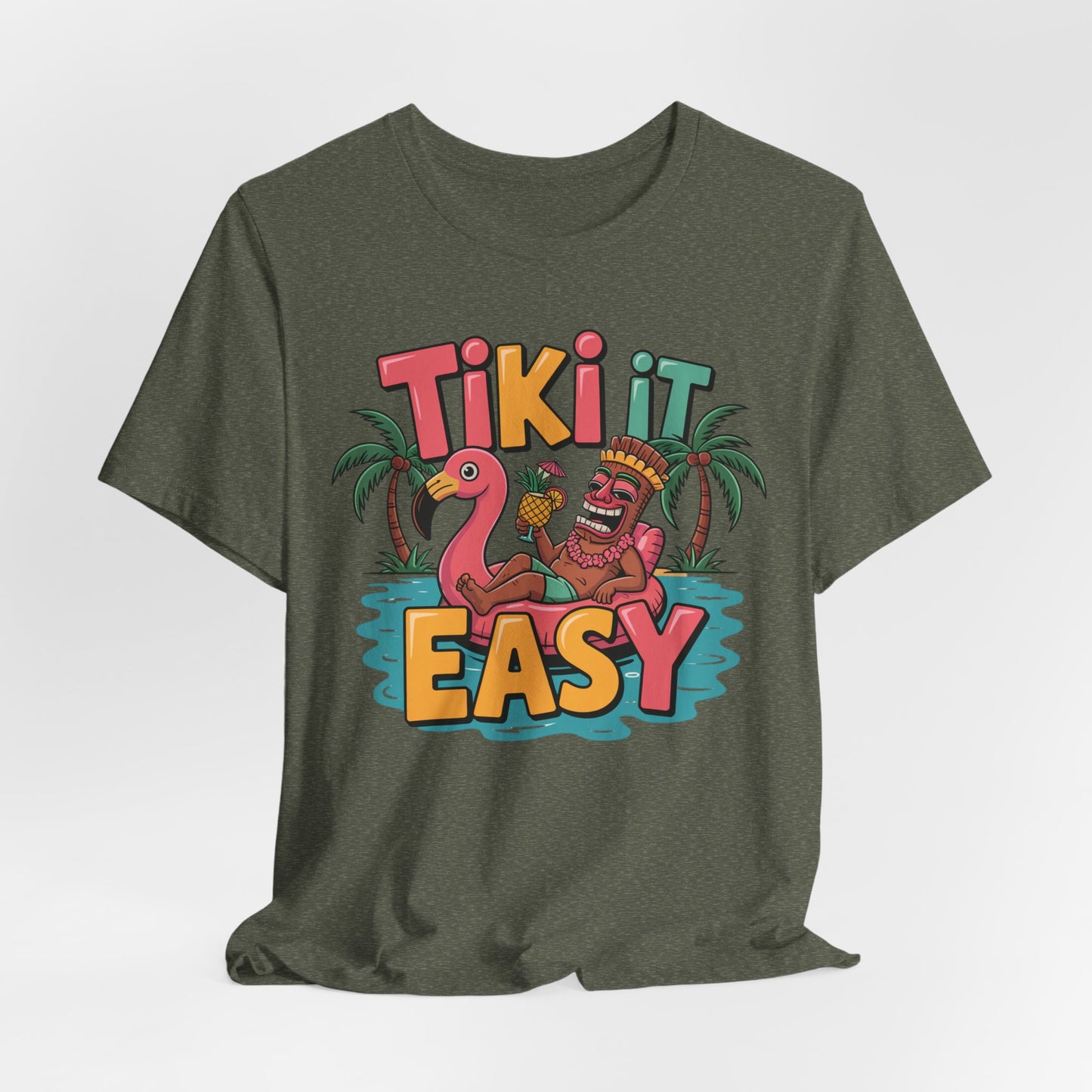 The Tiki It Easy Unisex Short Sleeve Tiki T-Shirt features a green design with a vibrant tiki statue on a flamingo float, palm trees, and bold “Tiki It Easy” text—perfect for showcasing tropical beach vibes.