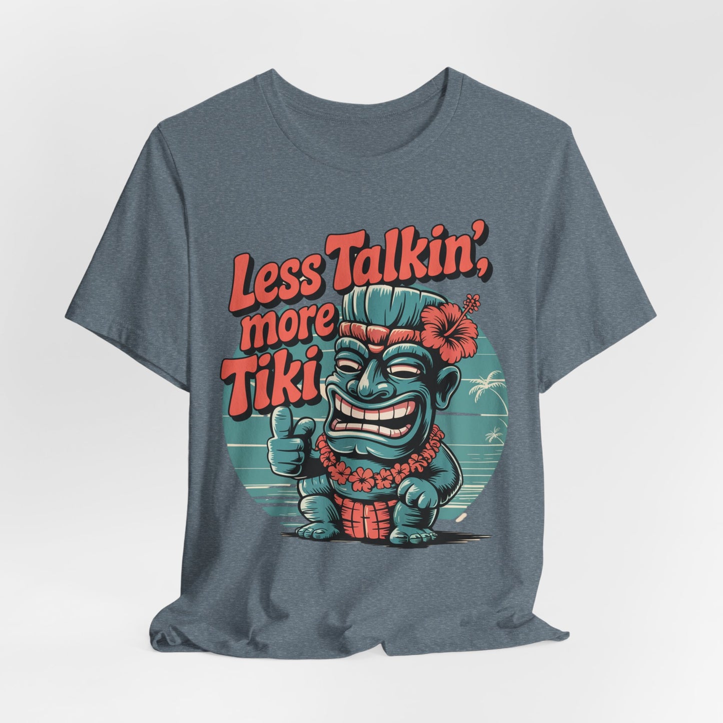 The Tiki Vibes Graphic Tiki T-Shirt - Less Talkin, More Tiki Unisex Shirt showcases a blue tiki giving a thumbs up, bold orange text, and tropical details on soft, breathable fabric.