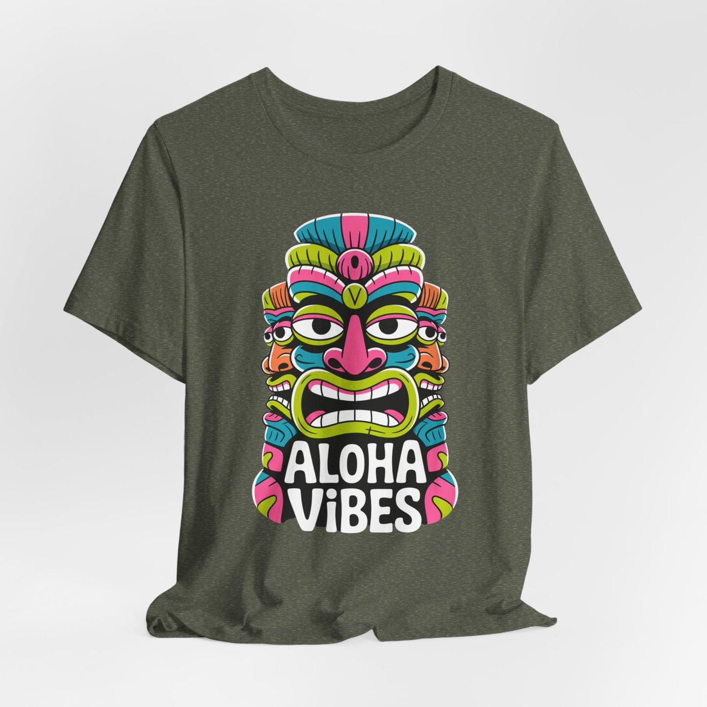 The Aloha Vibes Unisex Tiki T-Shirt features a dark green jersey, a colorful stylized tiki mask, and bold white text. Vibrant pink, blue, yellow, and green accents add fun summer vibes of adventure and relaxation.