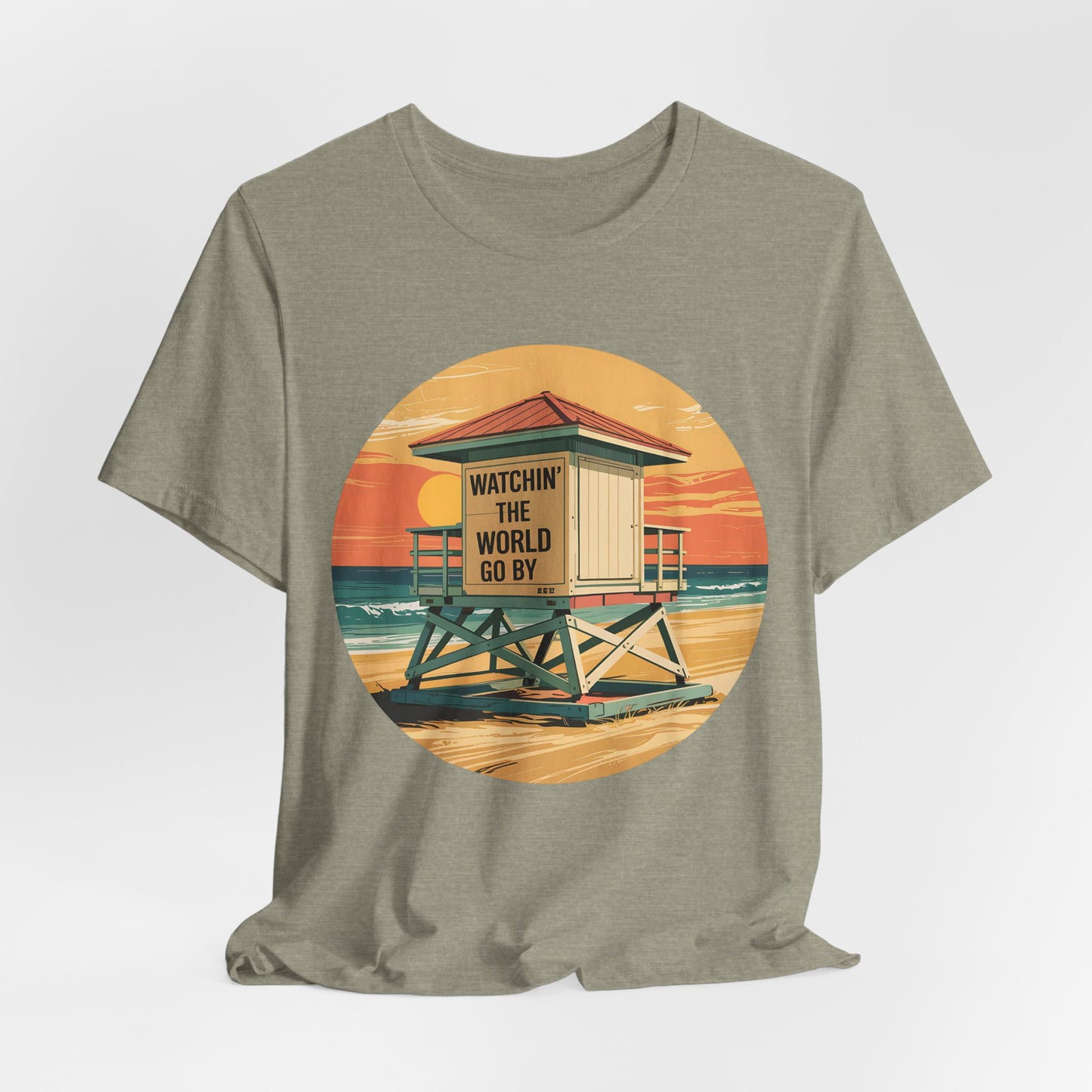 The Watchin The World Go By T-Shirt is a unisex jersey short sleeve shirt featuring a khaki color and a round sunset beach lifeguard tower graphic—a perfect pick for beach lovers and summer vacations.