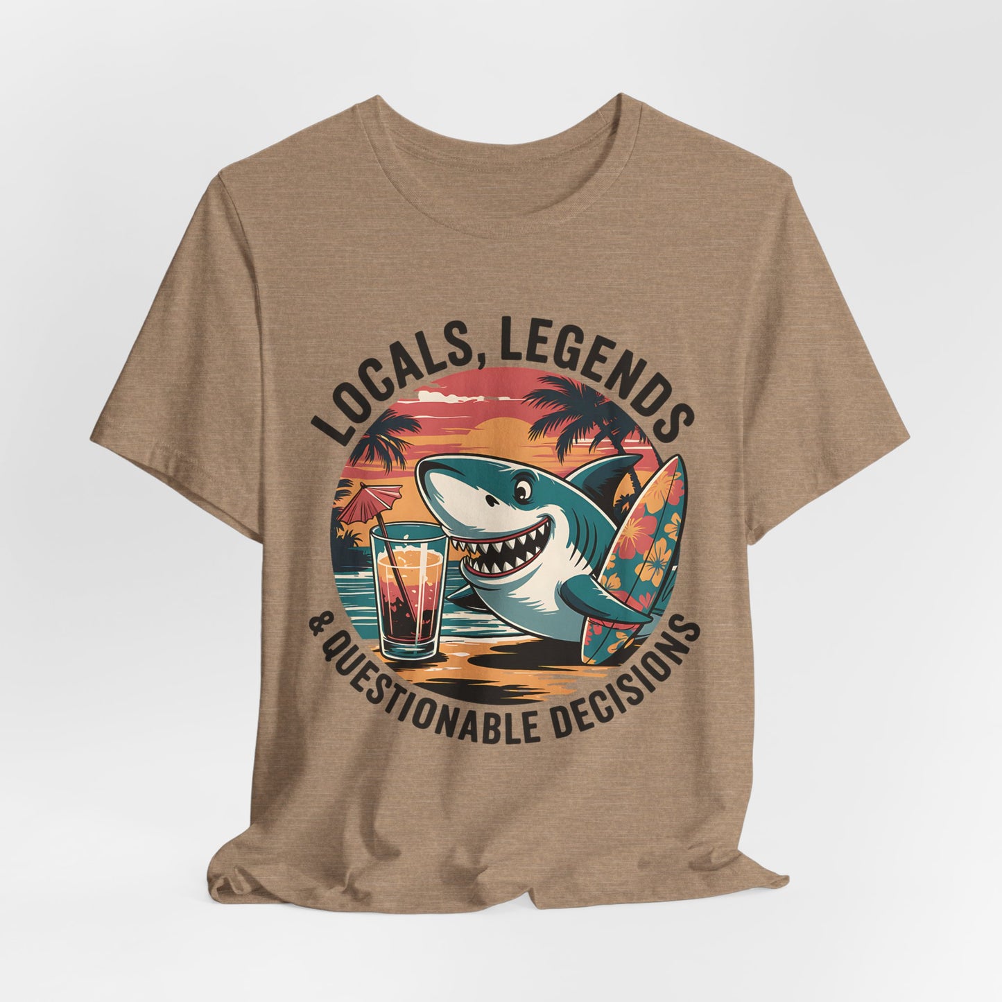 Rock beach vibes in the Funny Shark Graphic T-Shirt—Locals, Legends & Questionable Decisions. Features a cartoon shark with surfboard, tropical drink, palm trees, and sunset for laid-back style perfect for any beach lover!.