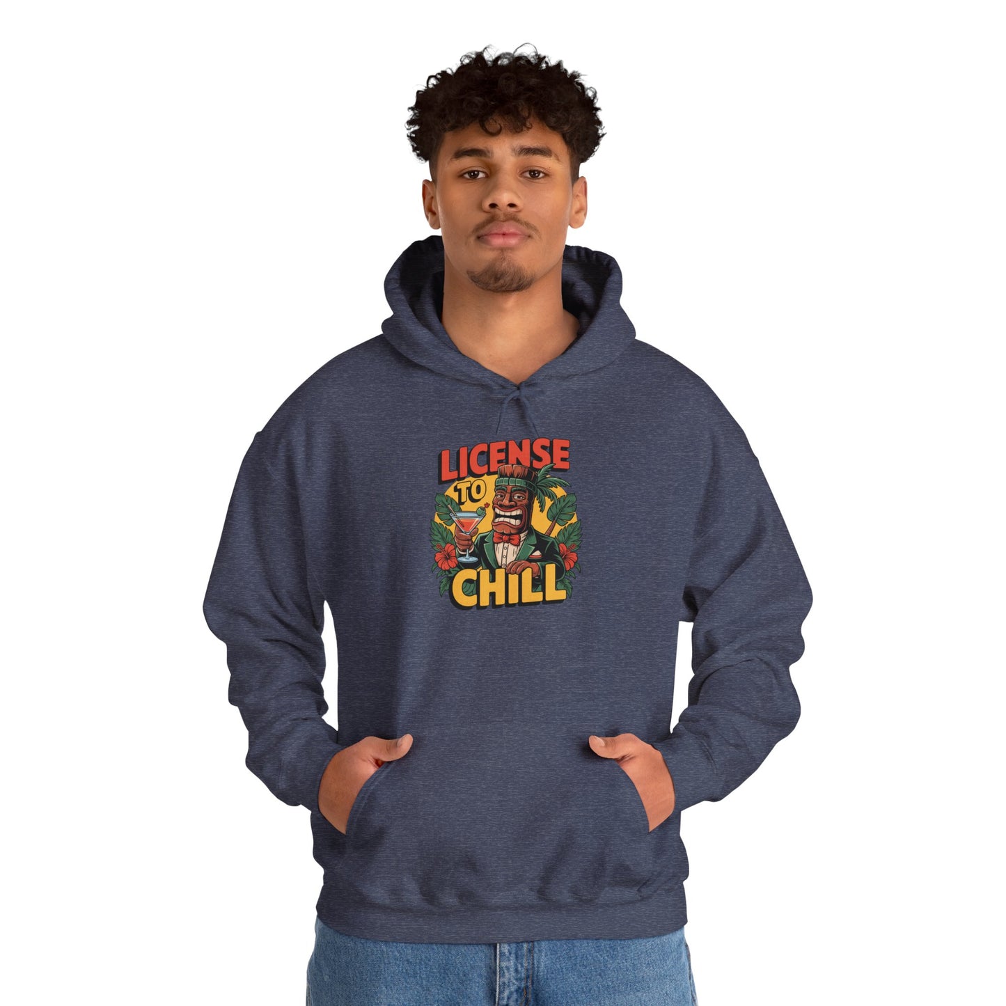 A young man wears the License to Chill Hoodie—an unisex heavy blend sweatshirt with a colorful chest graphic and “License to Chill” text. He has his hands in the front pocket; background is plain white, highlighting this relaxed, versatile staple.