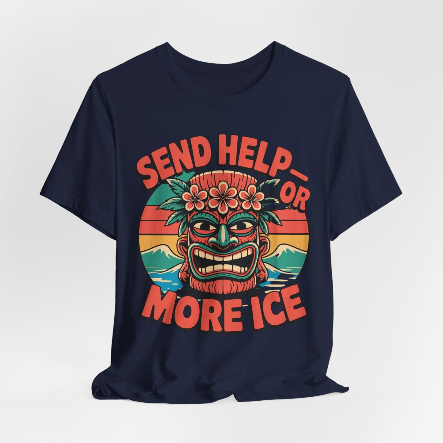 The Tropical Vibe Unisex Tiki T-Shirt features a navy blue jersey with a colorful tiki mask, tropical flowers, sunset, and bold orange text: “Send Help or More Ice.” Perfect for summer festivals and lovers of all things tropical.