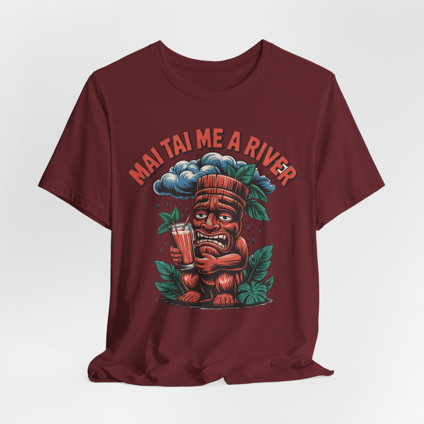 The Mai Tai Me a River Tropical Tiki T-Shirt is a maroon unisex tee with a cartoon tiki holding a drink and crying under a raincloud, “MAI TAI ME A RIVER” text, and tropical leaves for unique style.