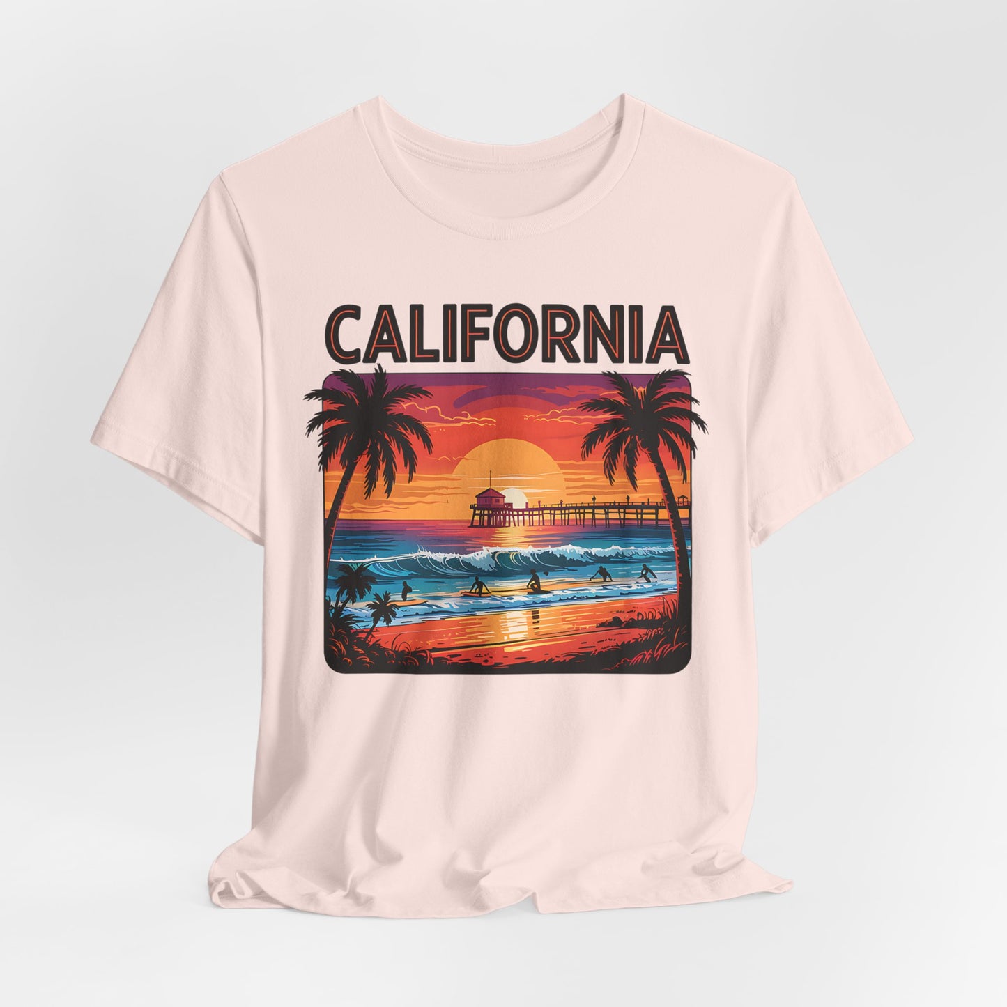 The California Sunset Unisex Jersey T-Shirt features a vibrant beach scene with palm trees, surfers, pier, waves, and bold CALIFORNIA text—perfect for beach lovers and fans of vintage-inspired casual style.