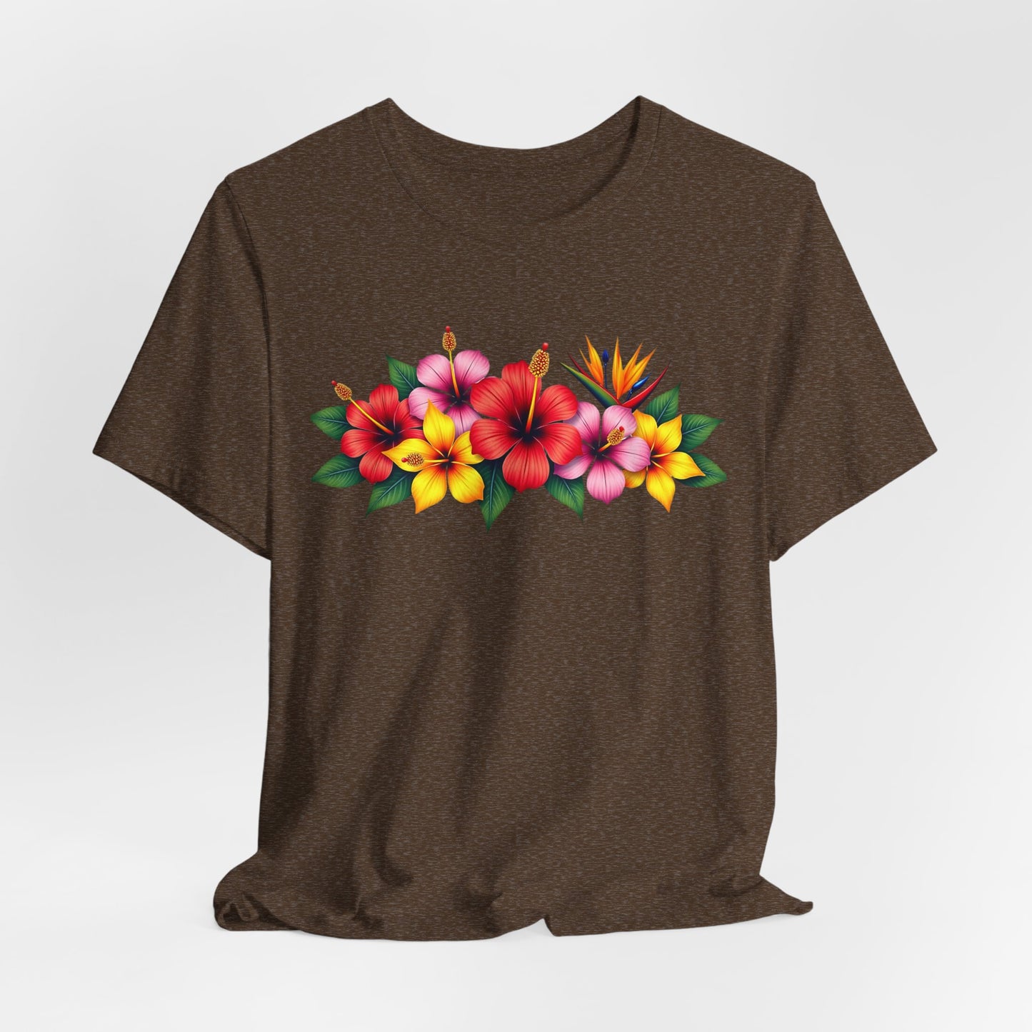 The Tropical Floral Unisex T-Shirt – Bright & Vibrant Summer Shirt features a dark brown base with red, pink, and yellow hibiscus flowers and green leaves across the chest, adding bohemian flair. Shown on a plain white background.