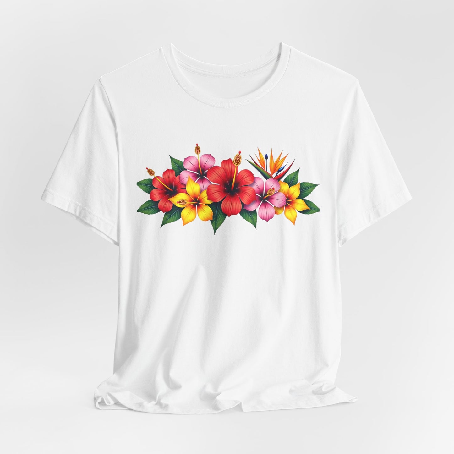 The Tropical Floral Unisex T-Shirt features a bright, vibrant horizontal floral print with red, pink, and yellow hibiscus and bird of paradise blooms—perfect for adding bohemian summer flair to your wardrobe.
