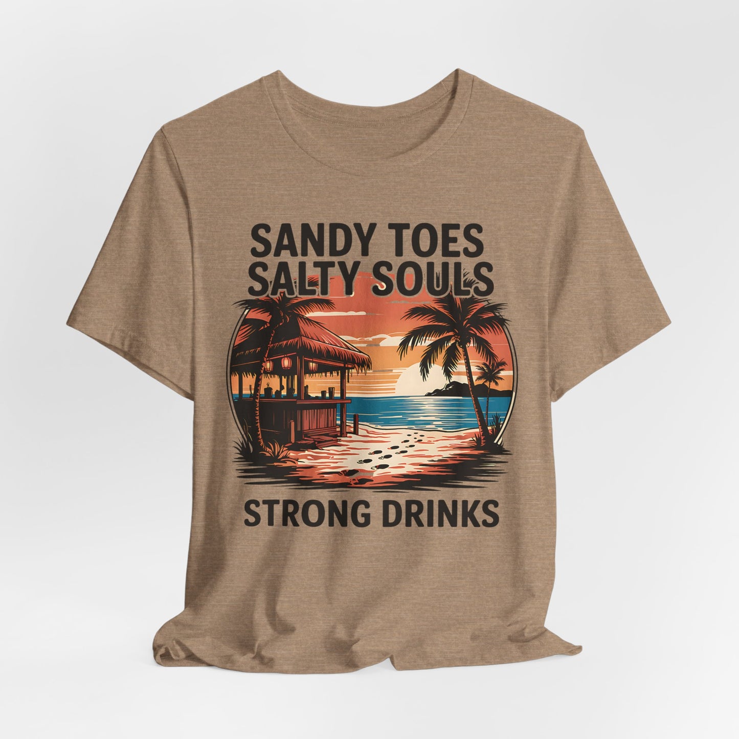 The Sandy Toes Salty Souls Tee - Unisex Jersey Short Sleeve for Beach Lovers features a tropical sunset with palm trees, hut, and ocean. Made from soft Airlume combed cotton. Text: Sandy Toes, Salty Souls, Strong Drinks.