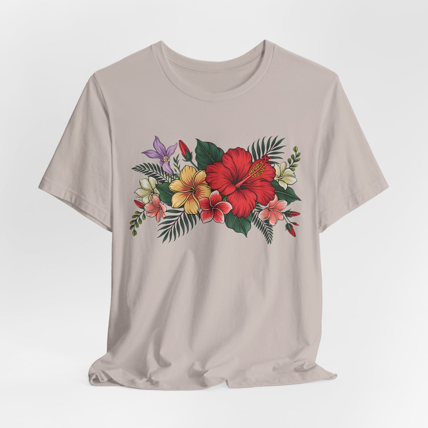 The Tropical Floral Unisex T-Shirt - Vibrant Summer Style features a beige base with a colorful floral design—red, yellow, and pink flowers, green leaves, and purple accents—crafted from soft Airlume cotton and shown on a plain white background.