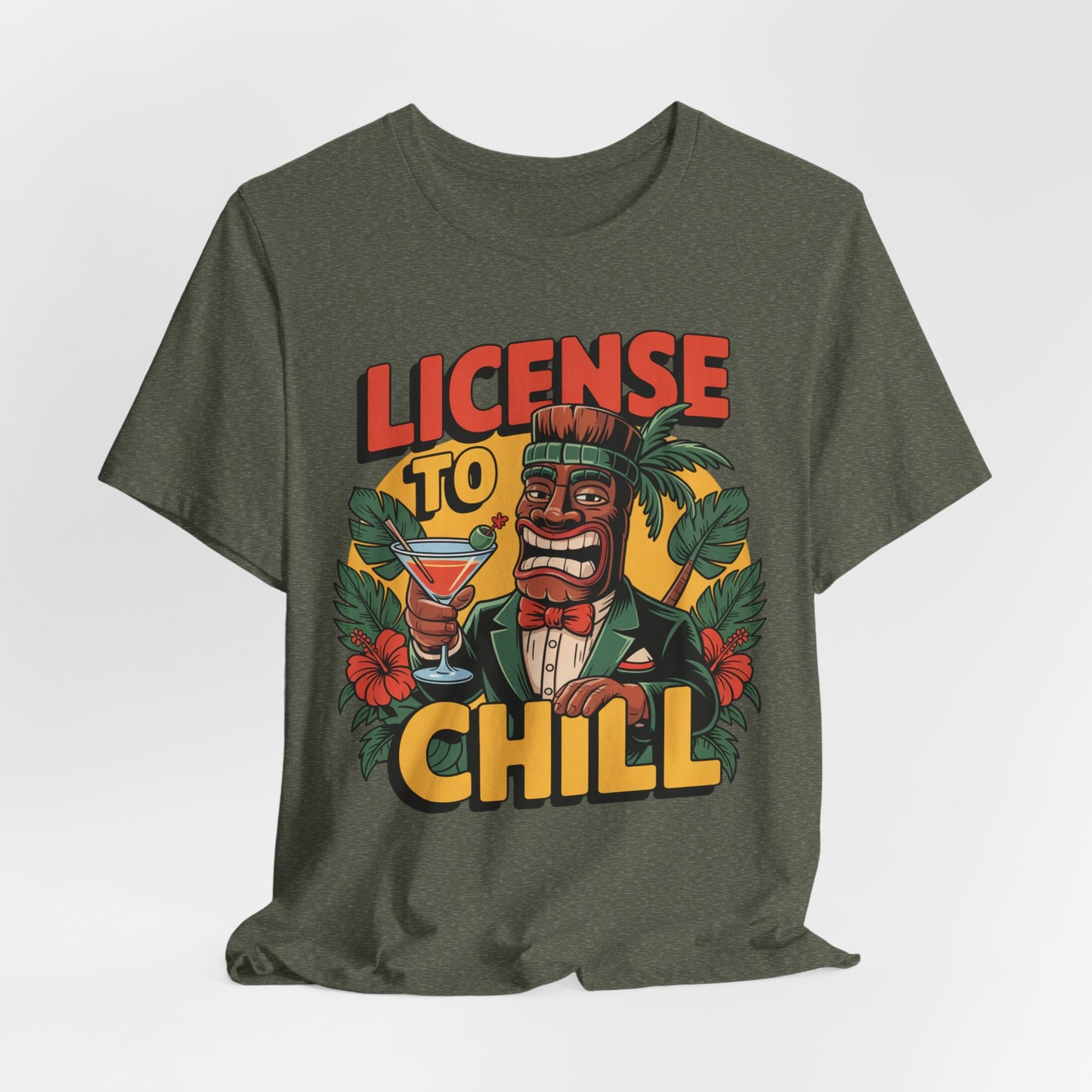A fun gift for summer BBQs, the T-Shirt - License to Chill Tropical Graphic Tiki T-Shirt showcases a cartoon tiki in a suit with a cocktail, tropical leaves and flowers, and bold LICENSE TO CHILL text.