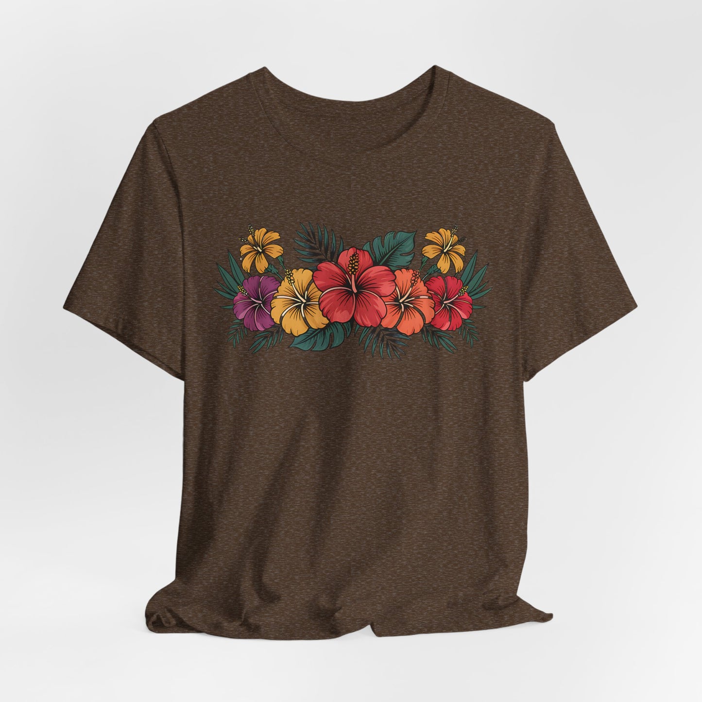 The Tropical Floral Unisex T-Shirt - Perfect for Summer Days is made from soft Airlume cotton and showcases a vibrant floral print with red, yellow, and purple hibiscus plus green leaves across the chest.