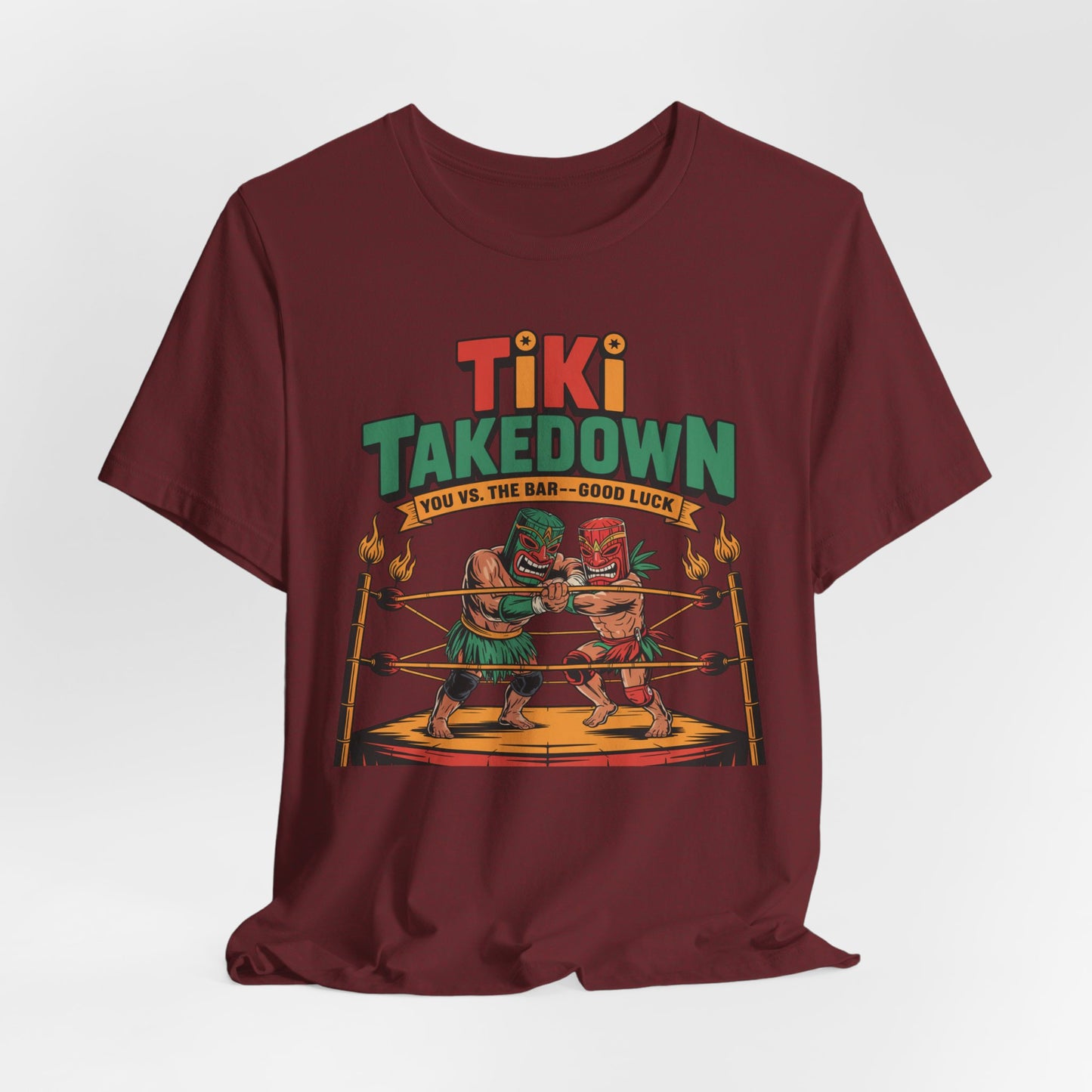 The Tiki Takedown Unisex Jersey Tiki T-Shirt features two tiki statues boxing in a torch-lit ring with Tiki Takedown, You vs. The Bar—Good Luck text. Made from soft Airlume cotton, its a fun graphic tee perfect for bar lovers.
