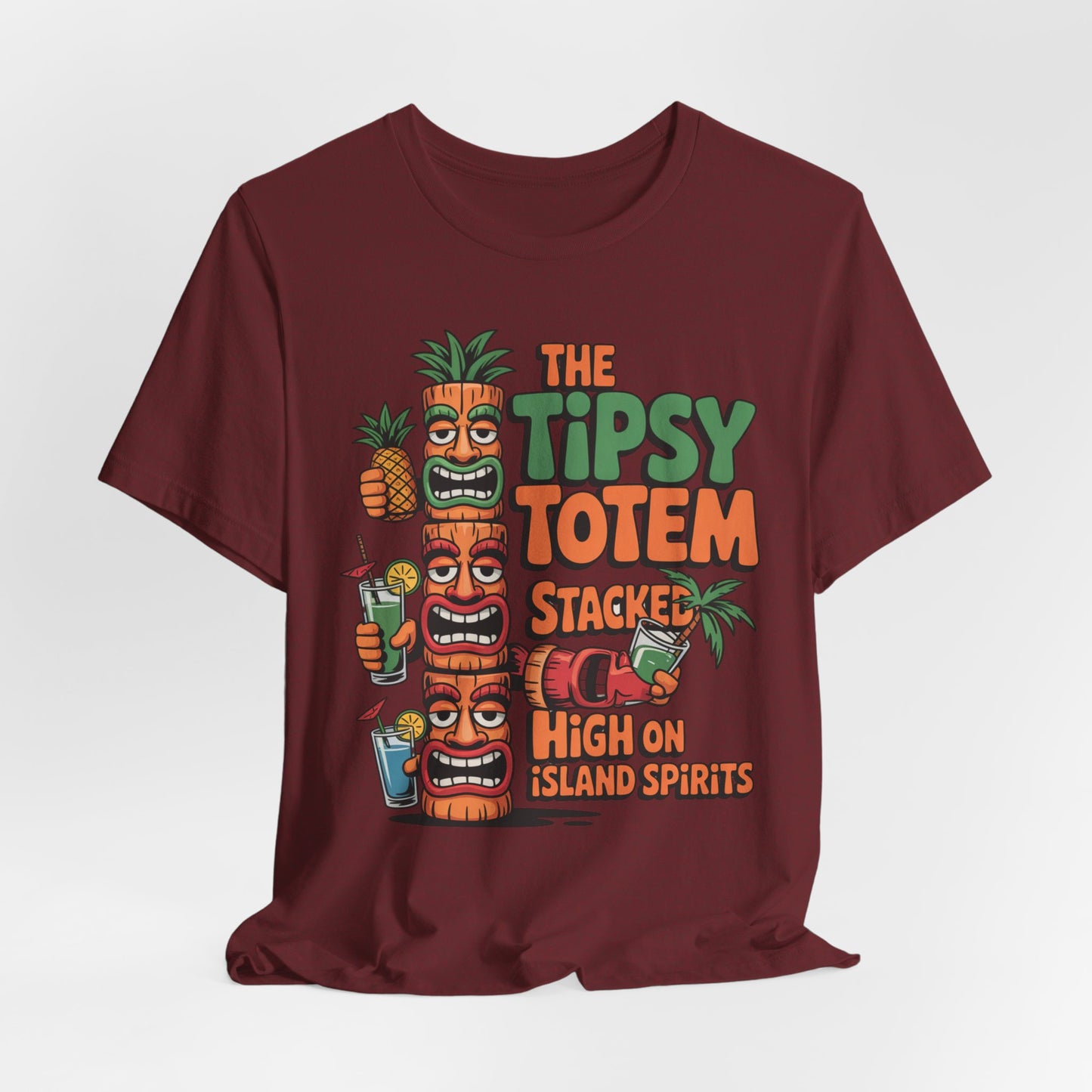 The Tiki Cocktail Tee - The Tipsy Totem Graphic Shirt features three vibrant tiki totems, tropical drinks, pineapples, and bold The Tipsy Totem text—perfect for summer parties or anyone seeking a fun island vibe.