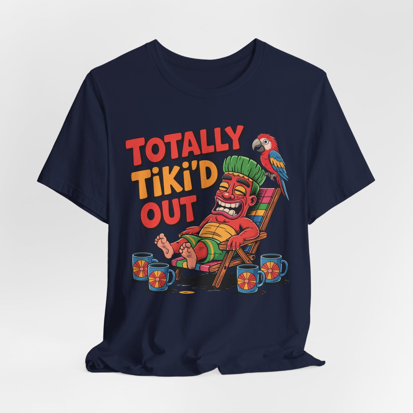 The Tiki Vibe Short Sleeve Tee - Totally Tikid Out Graphic features a navy unisex design with a relaxed tiki statue, parrot, drinks, and bold red and yellow “TOTALLY TIKI’D OUT” text—perfect for tiki lovers.