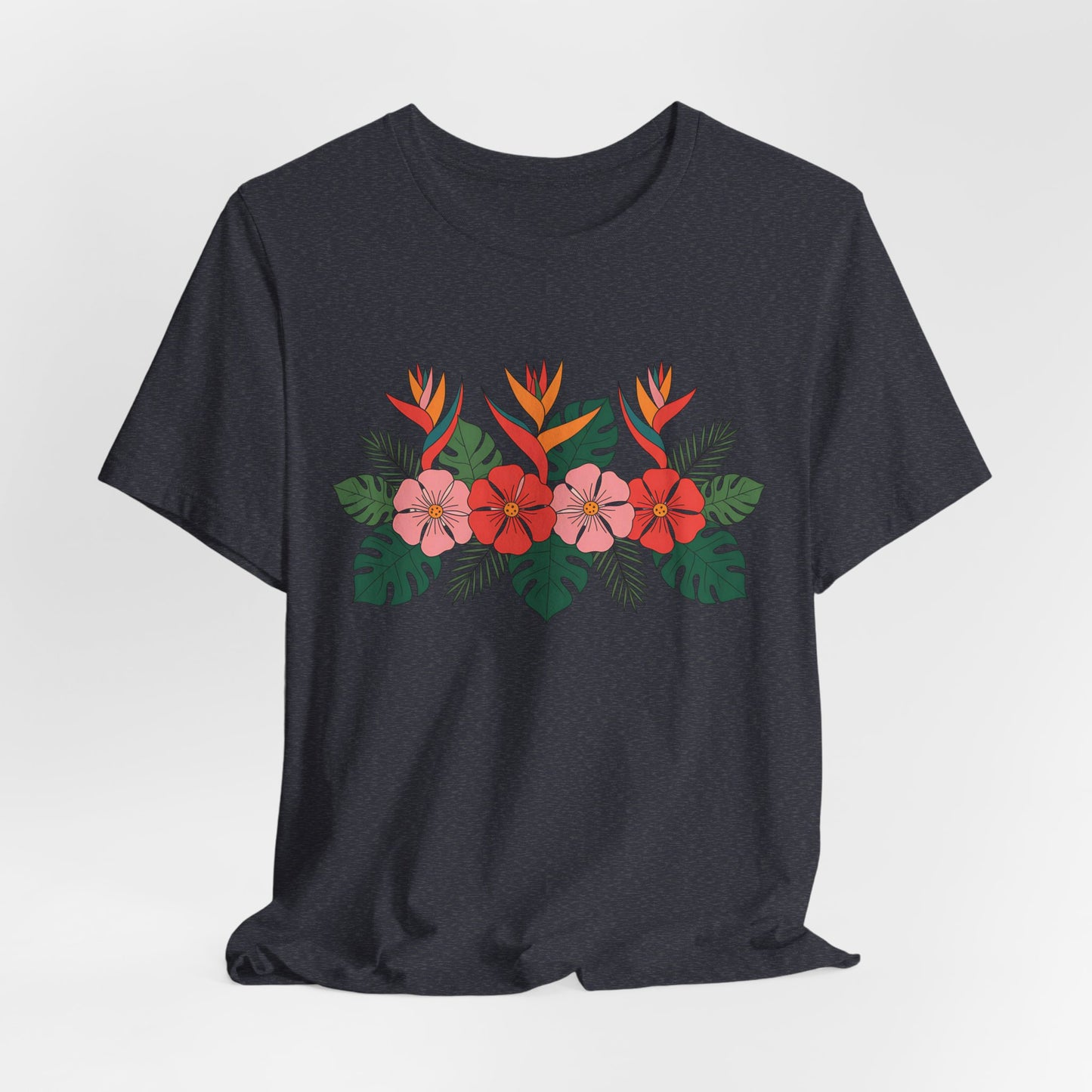 The Tropical Floral Unisex T-Shirt – Perfect for Summer Celebrations features a vibrant red, pink, and orange floral print with green leaves on dark gray breathable fabric, shown against a white background.