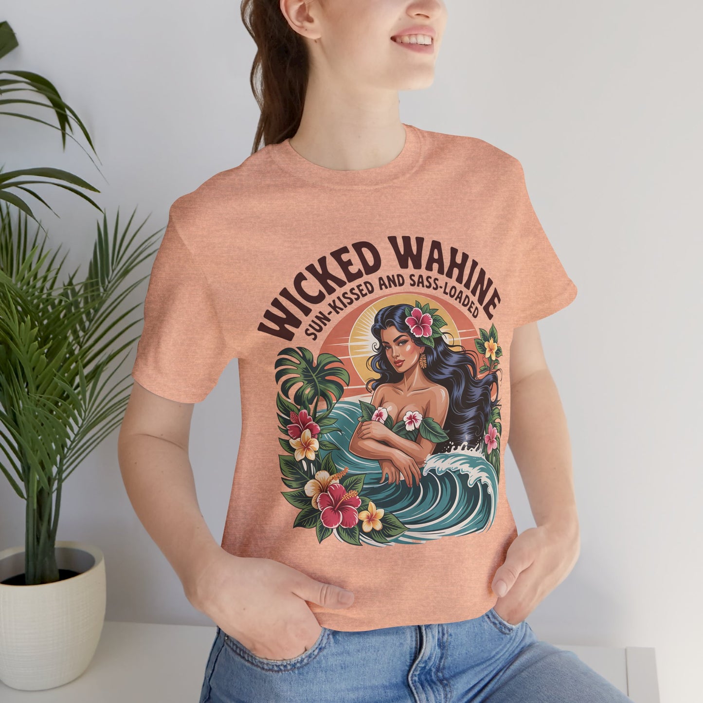 A woman models the Wicked Wahine Graphic T-Shirt—Sun-Kissed and Sass-Laden Unisex Jersey Shirt with a vibrant tropical design of a flower-crowned woman, waves, and leaves. Ideal for embracing a laid-back vibe among lush plants.