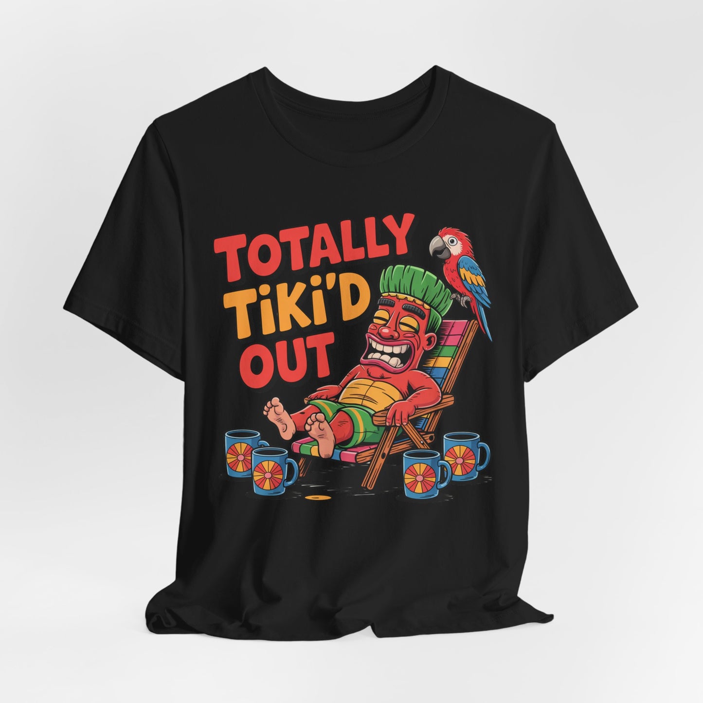 The Tiki Vibe Short Sleeve Tee – Totally Tiki’d Out Graphic is a black unisex shirt for tiki fans, featuring a colorful cartoon tiki lounging with mugs and a parrot, plus bold playful text: Totally Tiki’d Out.