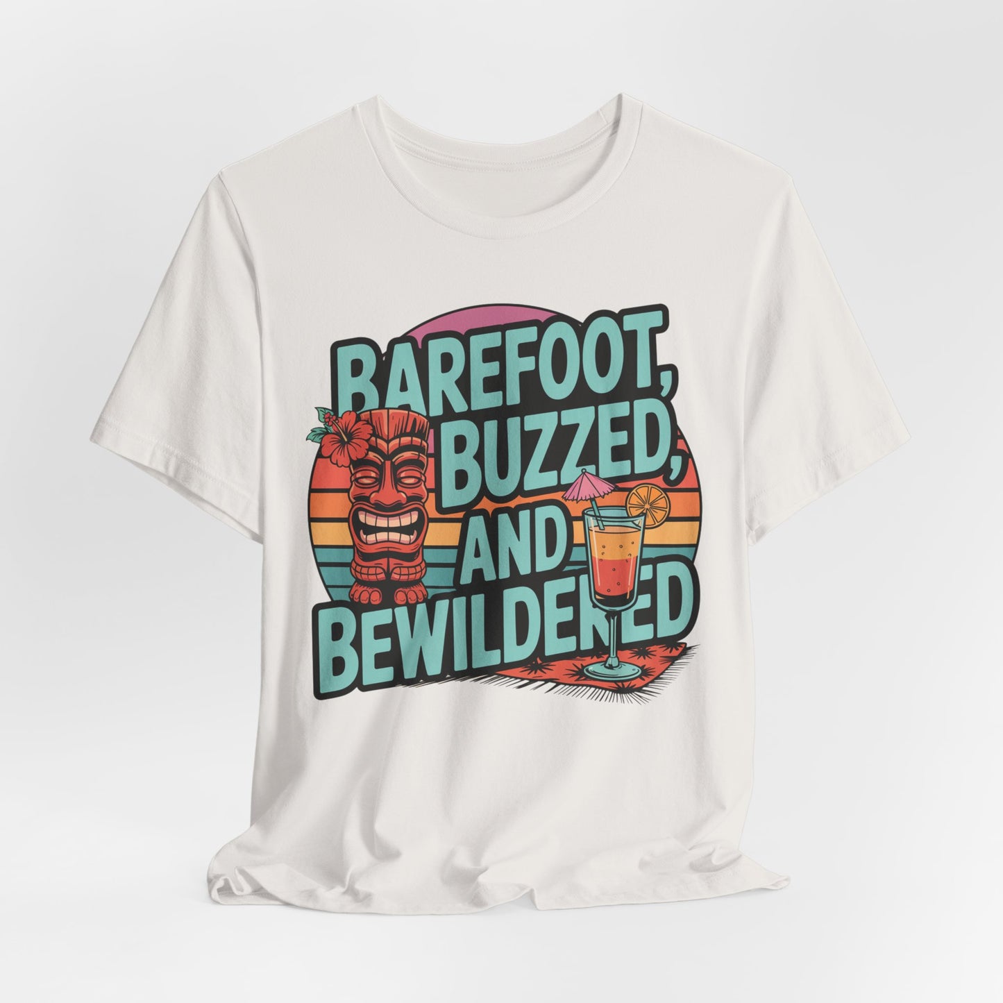 Tropical Vibes Tiki T-Shirt - Barefoot, Buzzed, and Bewildered: White unisex tee with a bold tiki statue, cocktail, and sunset design—ideal for summer celebrations. Features vibrant text: “Barefoot, Buzzed, and Bewildered.”.