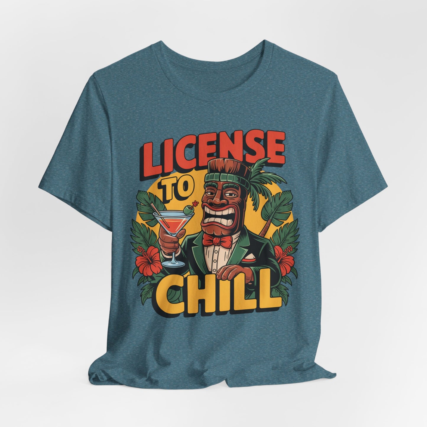 The T-Shirt - License to Chill Tropical Graphic Tiki T-Shirt features a vibrant tiki in a suit with a cocktail, set among tropical leaves and flowers, plus bold LICENSE TO CHILL text—a fun unisex gift for any summer barbecue.