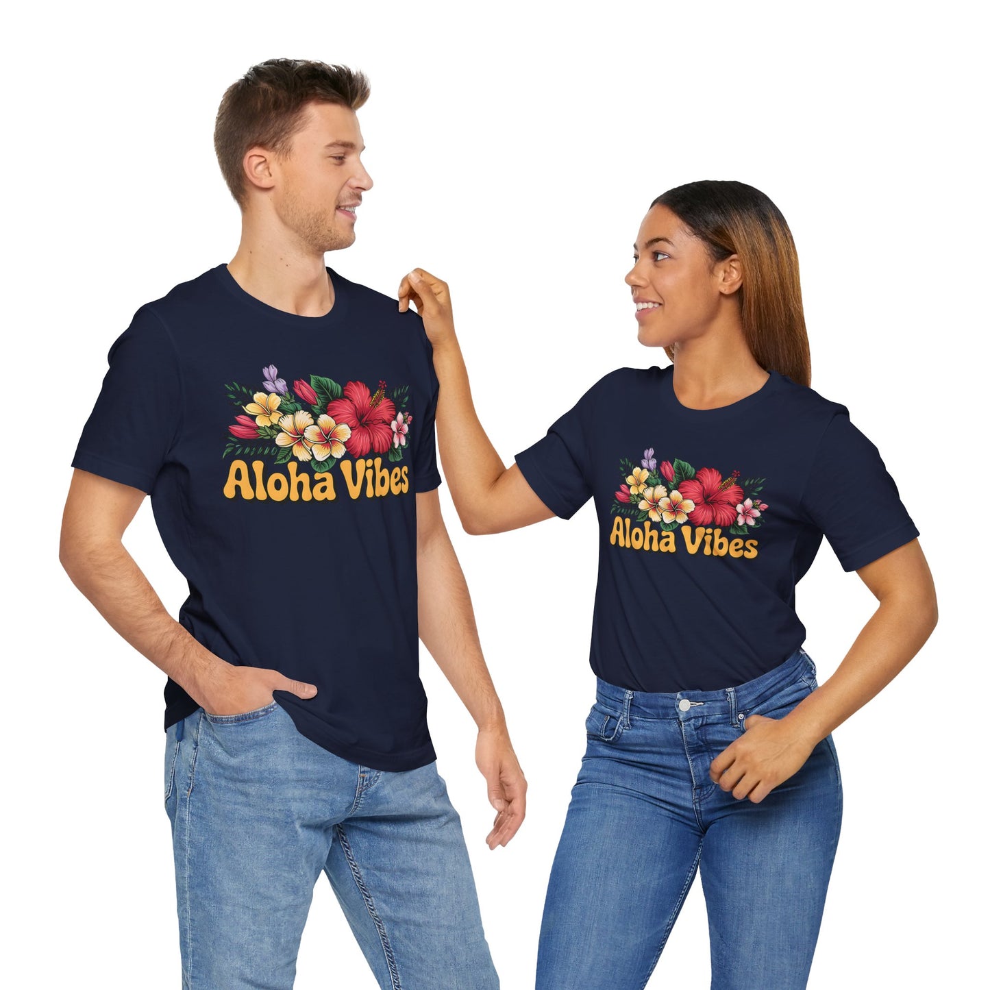 A man and woman in matching Aloha Vibes Floral Unisex T-Shirts for Island Vibes smile at each other in blue jeans, enjoying the breathable comfort and effortless style of these colorful designs.